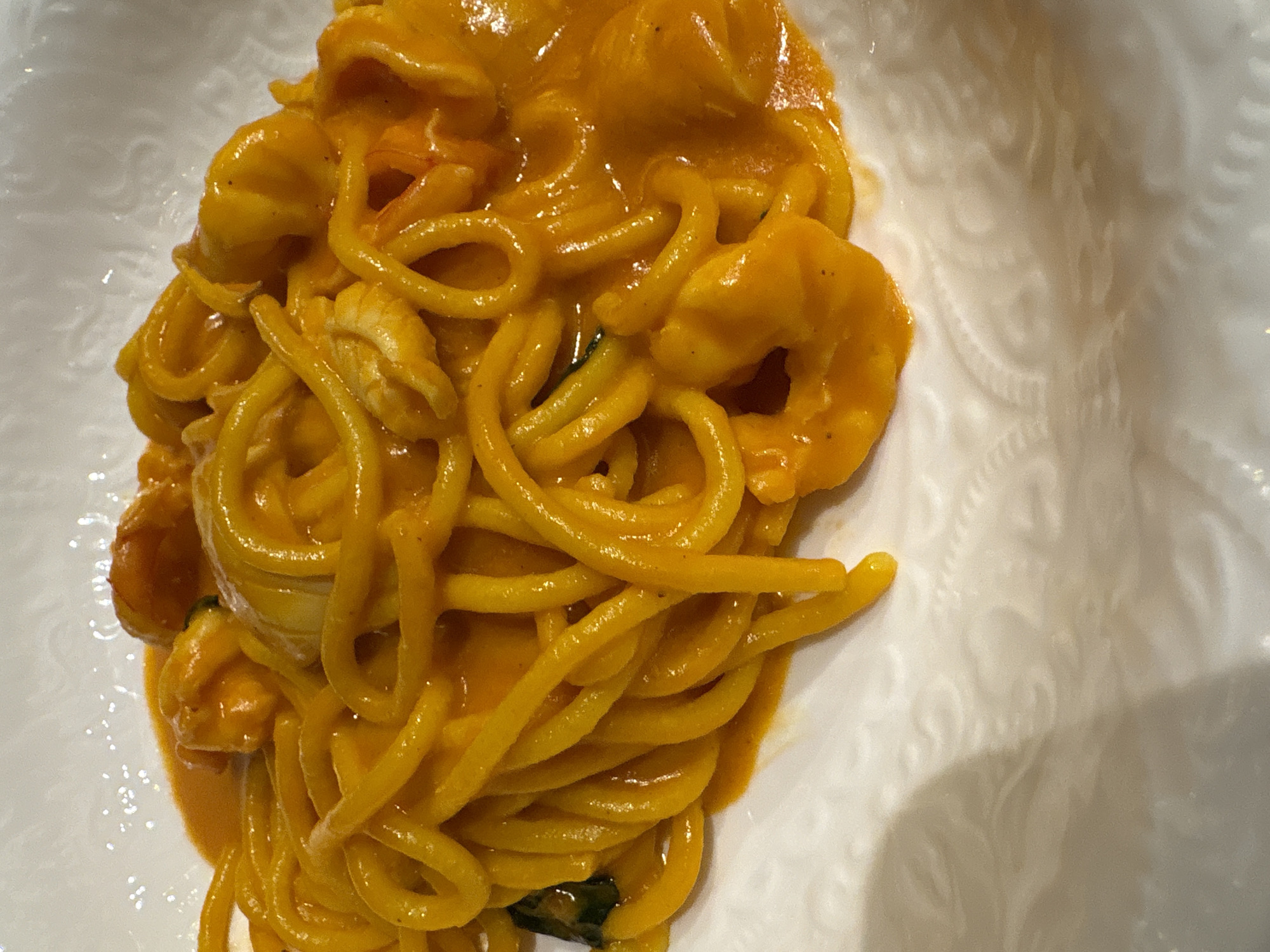 A close-up, overhead shot shows a portion of food on a white, patterned plate. The food appears to be pasta, likely spaghetti or a similar type, coated in a creamy, orange sauce. There are shrimp mixed in with the pasta. The photograph exhibits a slightly soft focus. There is no information about the location of the city of Kazan, Russia.