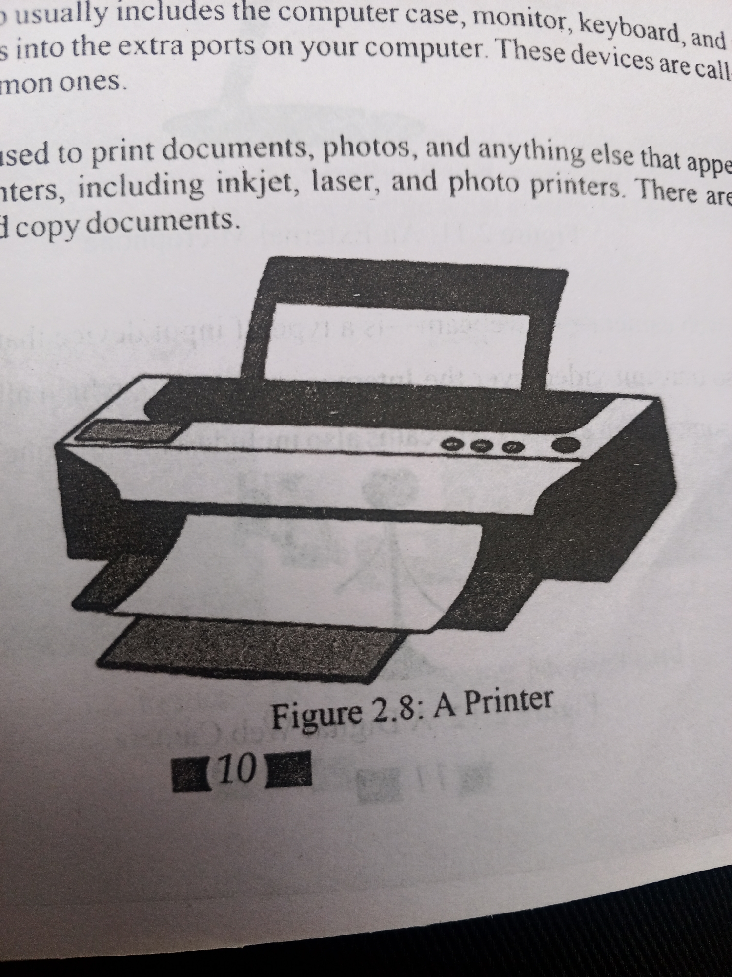 The media file displays a page from a book or document. The primary subject is an illustration of a printer, labeled as "Figure 2.8: A Printer". The illustration is black and white and shows a typical desktop printer with paper output.
Above the illustration, there is text describing computer peripherals. The visible text reads: "usually includes the computer case, monitor, keyboard, and s into the extra ports on your computer. These devices are call mon ones. ased to print documents, photos, and anything else that appe nters, including inkjet, laser, and photo printers. There are d copy documents."
Below the illustration, the figure number and title are clearly visible: "Figure 2.8: A Printer". There is also a number "10" displayed within black boxes, likely indicating a page number or item number. The background of the image is a plain, lightly textured surface, possibly a desk or table, and the overall lighting suggests an indoor setting. No people are visible in the media file. The context provided indicates the location is Jalingo, Nigeria, but this cannot be visually inferred from the image itself. The media file captures a segment of educational or informational material related to computer hardware.
---
The OCR of the image is:
--- OCR Start ---
usually includes the computer case, monitor, keyboard, and
s into the extra ports on your computer. These devices are call
mon ones.
ased to print documents, photos, and anything else that appe
nters, including inkjet, laser, and photo printers. There are
d copy documents.
Figure 2.8: A Printer
10
--- OCR End ---