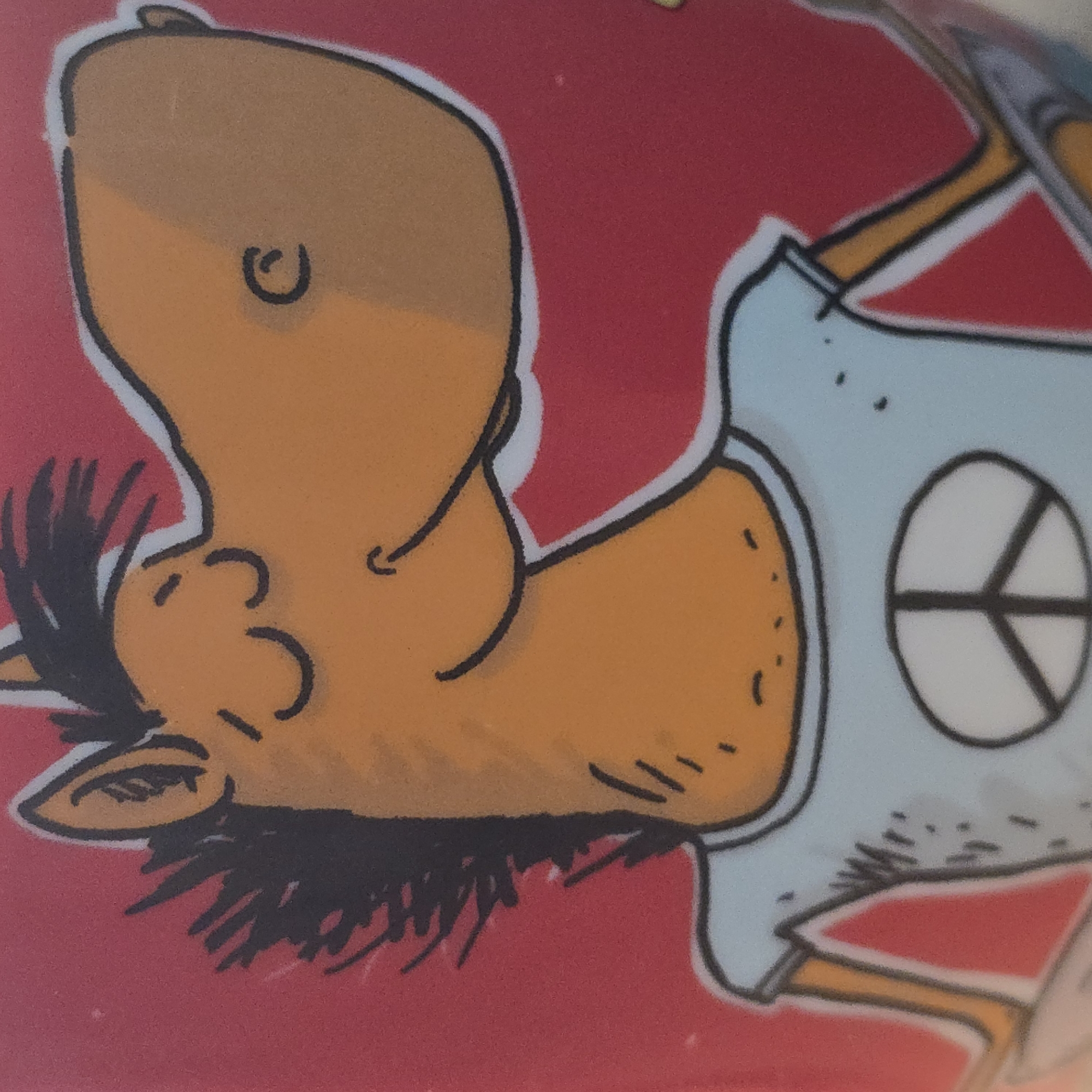 The image is a close-up of a cartoon drawing of a horse wearing a light blue t-shirt with a white peace symbol on it. The horse has orange skin, black mane and eyebrows, and is depicted with its eyes closed and a smiling mouth. The background is red. There is no discernible location within the city of Bryansk, Russia.