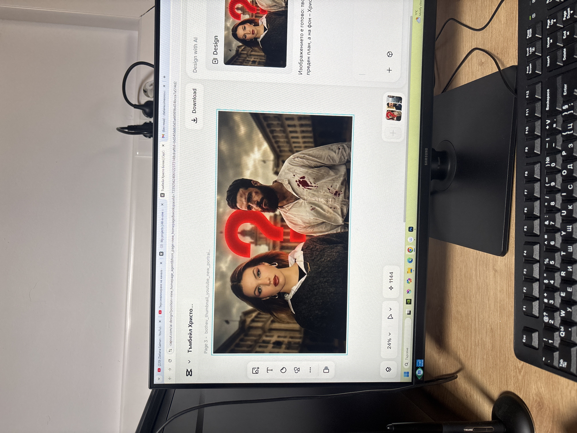 A computer monitor is captured from a slightly elevated, angled perspective, resting on a wooden desk. To the right of the monitor, a black keyboard with Cyrillic characters is visible. The monitor, branded "SAMSUNG," displays a graphic design application, likely CapCut based on the URL in the browser tabs.
The screen's main content is a composite image, seemingly a YouTube thumbnail, featuring two individuals against an urban background of classic architecture. In the upper part, a bearded man with a serious expression wears a white shirt visibly stained with blood. Below him, a woman with a neutral to slightly serious expression looks forward, wearing a dark sweater over a white collared shirt. A large red question mark ("?") is prominently overlaid on the image, partially covering both figures.
The interface shows various design tools and options, including "Download," "Design with AI," and a zoom level of "24%." Bulgarian text on the screen reads "Тъмбейл Христо..." (Thumbnail Hristo...) and "Изображението е готово: тво преден план, а на фон - Хрис" (The image is ready: your foreground, and in the background - Hris...). Open browser tabs suggest work on a YouTube channel, with one specifically mentioning "Тъмбейл Христо Ботев" (Thumbnail Hristo Botev). The Windows taskbar displays the current weather as "11°C Mostly cloud..."
The scene is an indoor workspace, likely an office or home setup. Wires and what appears to be a pair of earphones are located behind the monitor. The presence of Cyrillic text and the Hristo Botev reference strongly suggest the location context of Plovdiv, Bulgaria, and the activity is digital content creation, possibly for a historical or dramatic YouTube video.