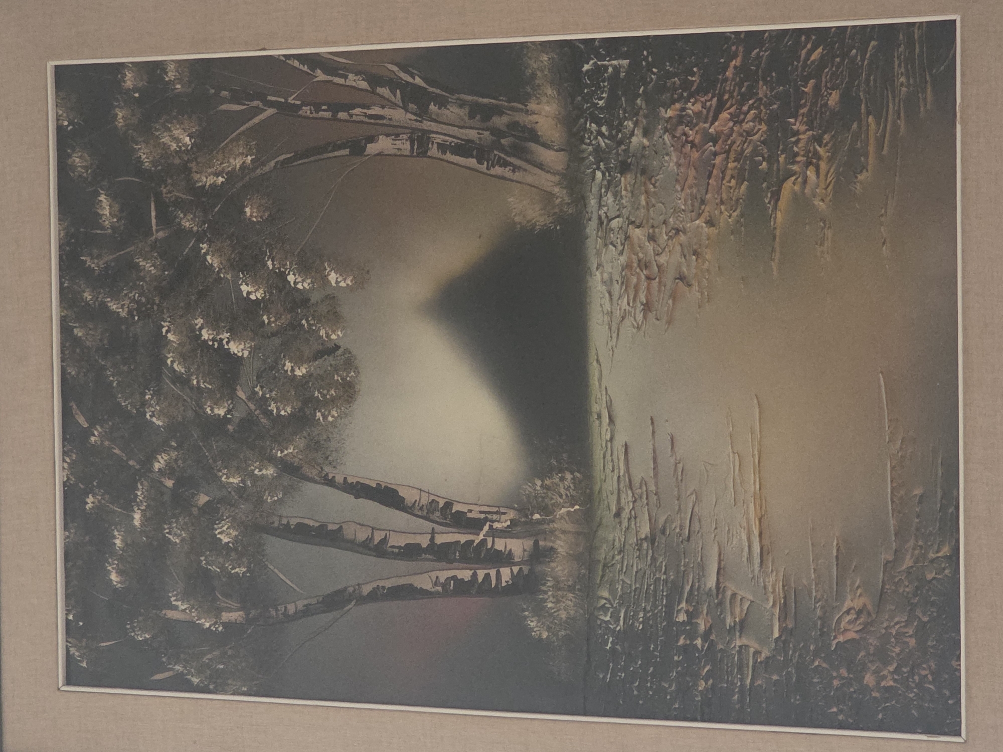 The image is a framed painting depicting a surreal landscape. In the foreground, a textured path or ground with rough, layered surfaces leads into the scene. The path is rendered in dark tones with hints of orange and yellow. The middle ground features a shadowy, conical shape, possibly a mountain or a tent, illuminated by a soft light emanating from behind it. To the left and right of this central feature are trees with distinctive white and dark bark, resembling birch trees. The upper portion of the painting is dominated by the dark, leafy canopies of these trees. The overall mood is atmospheric and somewhat mysterious, with a soft, diffused light. The painting is housed in a simple, light-colored frame against a neutral background. There is no indication of the city of Ladispoli, Italy, or any identifiable landmarks within the painting itself.