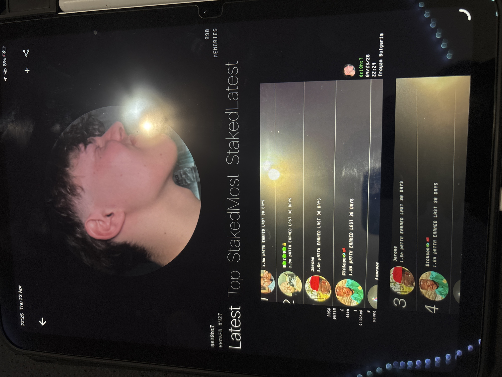 The image depicts a screen capture of a mobile device displaying an application related to cryptocurrency staking. The screen shows a profile picture of a person (de18ht7) with the text "RANKED #427" beneath the username. Text on the screen reads "Latest Top StakedMost StakedLatest". A list of users ranked by earnings is displayed on the right. Each user entry includes a profile picture, username (e.g., B1060, Jerome, Dickson), and the amount of PATTH earned in the last 30 days. The profile also shows: de18ht7, date as 04/23/26 and time as 22:24 and location as Troyan Bulgaria.