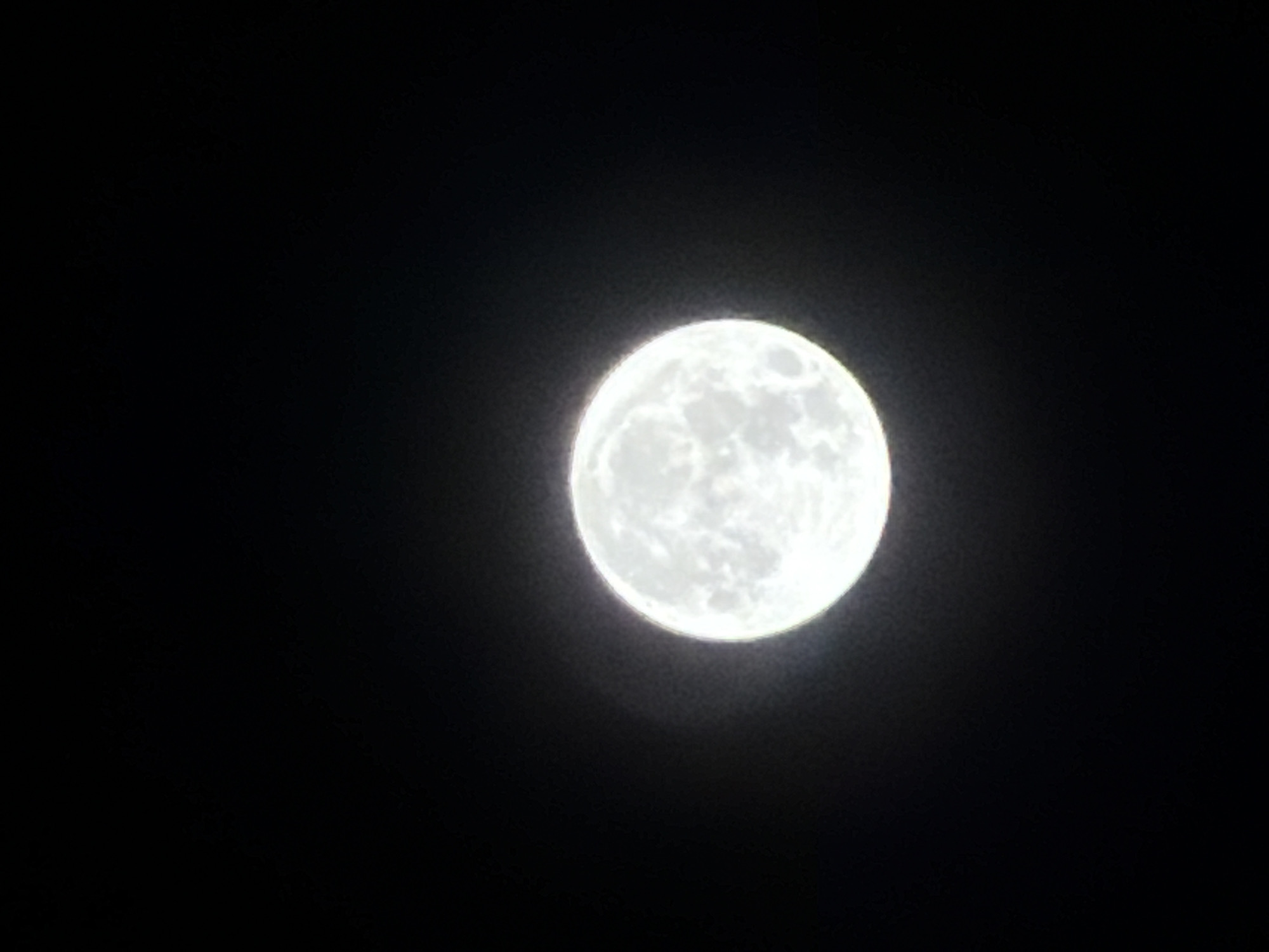A full moon, seemingly photographed at night, is centered on the right side of the frame against a stark black background. No discernible landmarks or other features can be made out in the surrounding area, so the location of this image in Đà Nẵng, Vietnam cannot be assessed with just the information provided. The moon is a bright, spherical object with visible surface details and a slight halo around its edges.