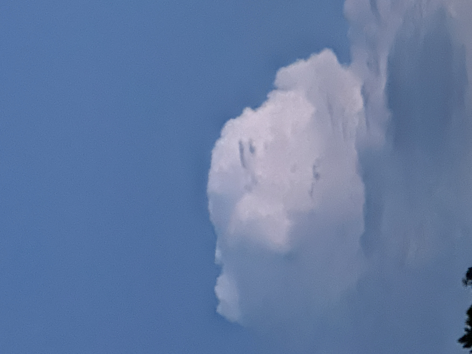 The image shows a white cloud in a blue sky. The cloud is puffy and has a somewhat amorphous shape. The photograph appears to be taken during the daytime. There are no visible people, specific objects, or discernible actions in the image, nor any way to discern if the image was taken in Vila Real, Portugal.