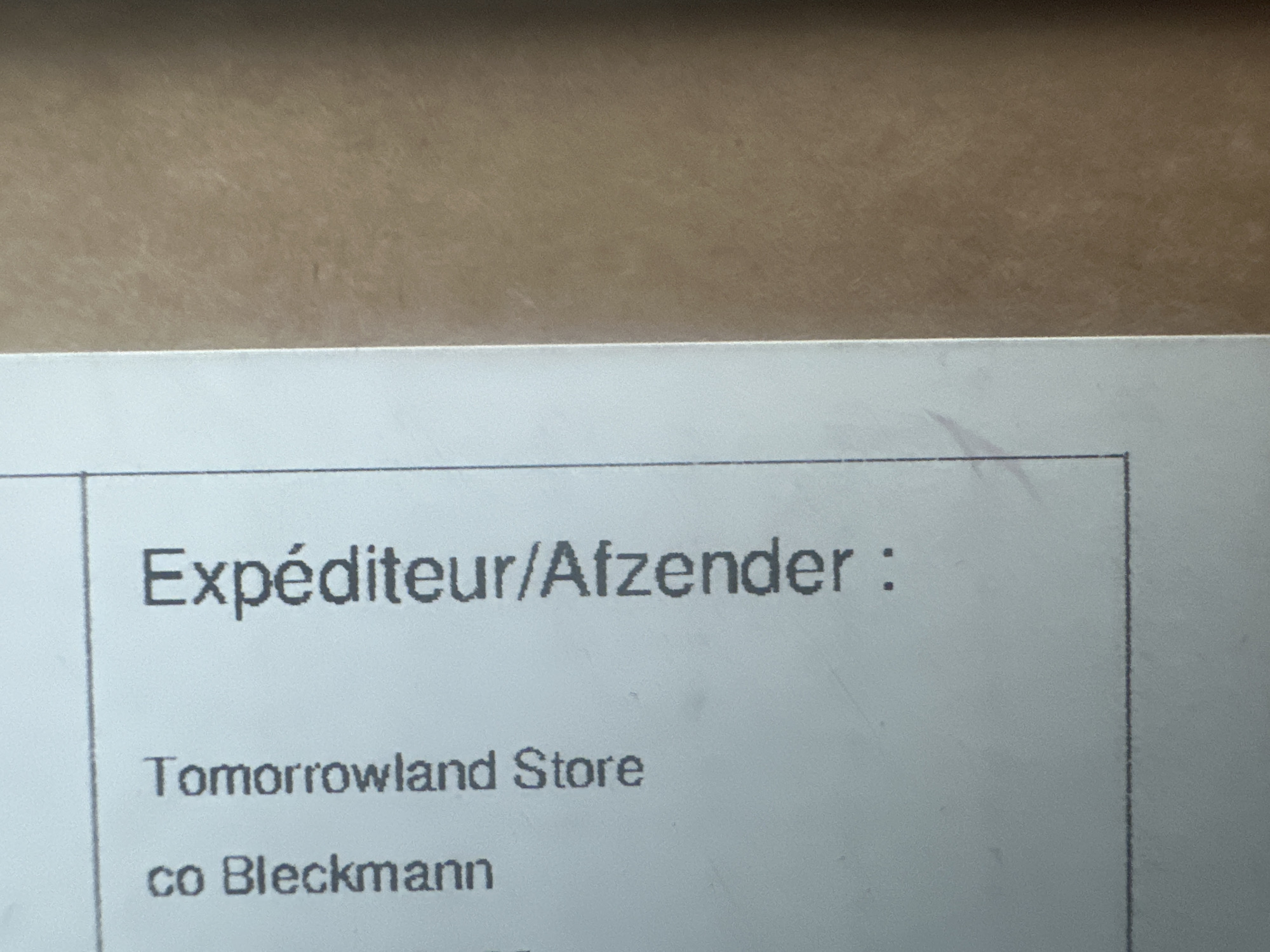 The image shows a portion of a shipping label with the heading "Expéditeur/Afzender:", which means "Sender" in French and Dutch, respectively. Below the heading, the label reads "Tomorrowland Store" and "co Bleckmann". This indicates that the item was sent from the Tomorrowland Store through Bleckmann. While the image does not explicitly state the location in Nivelles, Belgium, Bleckmann is a logistics company known to have operations there. Therefore, it can be inferred that the item originated from a logistics facility associated with Bleckmann, possibly located in Nivelles, Belgium.