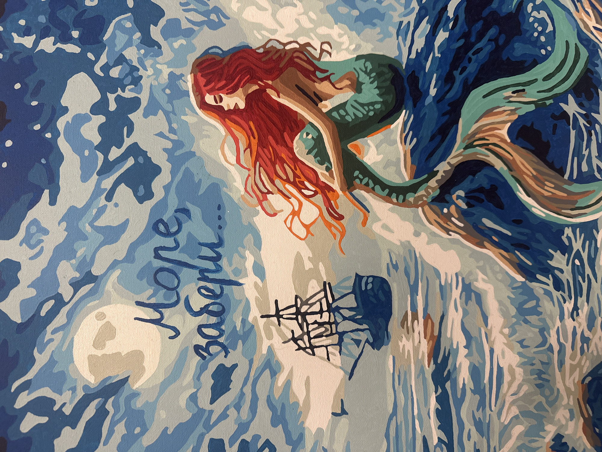 This is a painting of a mermaid sitting on a rock in the sea, with a sailing ship in the distance. The moon is visible in the sky, and there are waves crashing around the mermaid. The painting appears to be in the style of "paint by numbers." There is no discernible location within the city of Magnitogorsk, Russia, as the scene is an artistic rendition of a fantasy seascape.