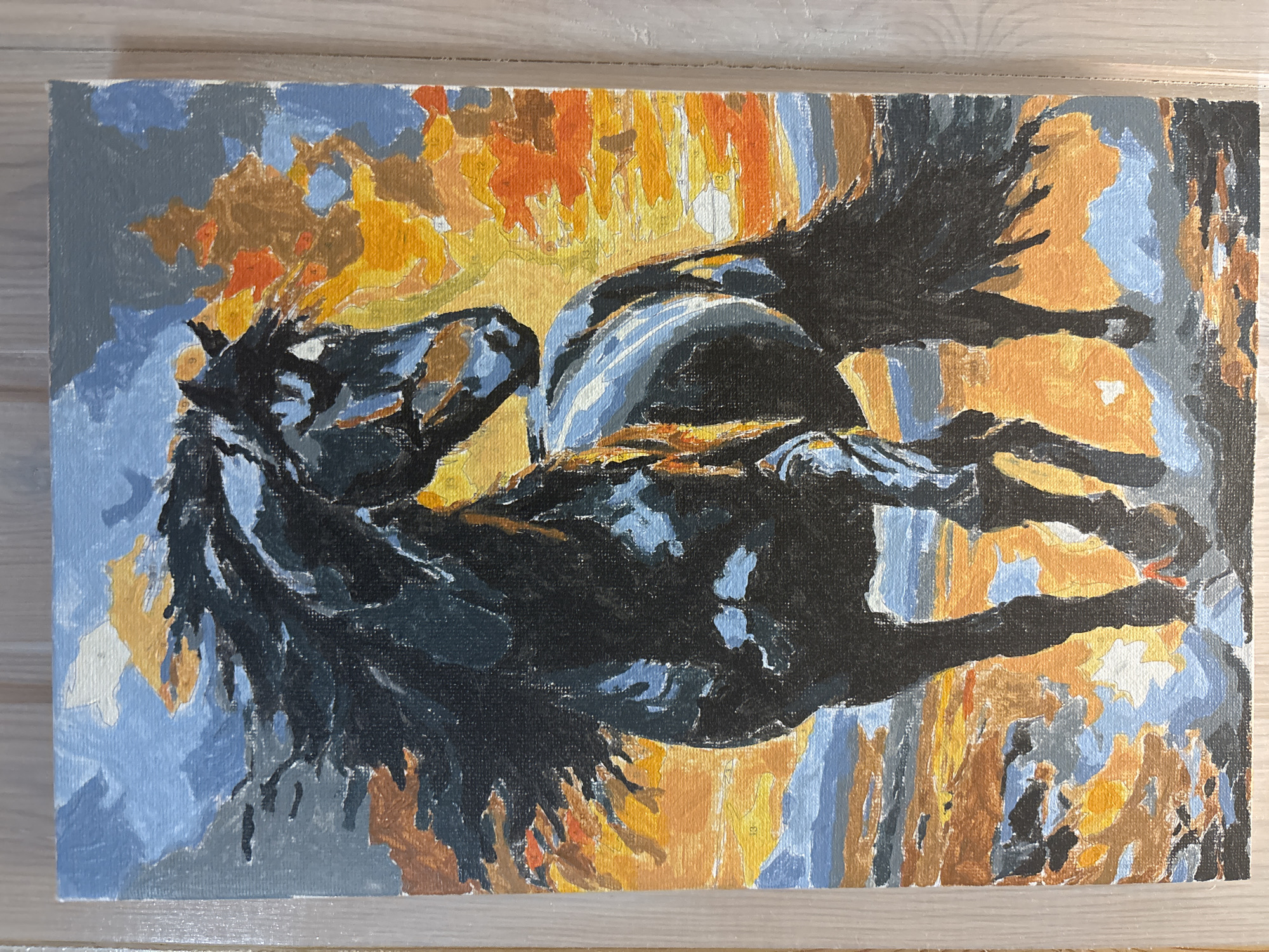 A painting of a black horse is on a wooden surface. The background consists of a variety of colors, including orange, yellow, blue, brown, white, gray, and black. The horse is the central subject, and the background appears to be abstract and stylistic. The painting is lying flat on a wooden surface, possibly a table or floor. There is no specific indication of the city of Zagatuy or any evidence of people or interactions within the scene depicted. The primary object is the painting itself.