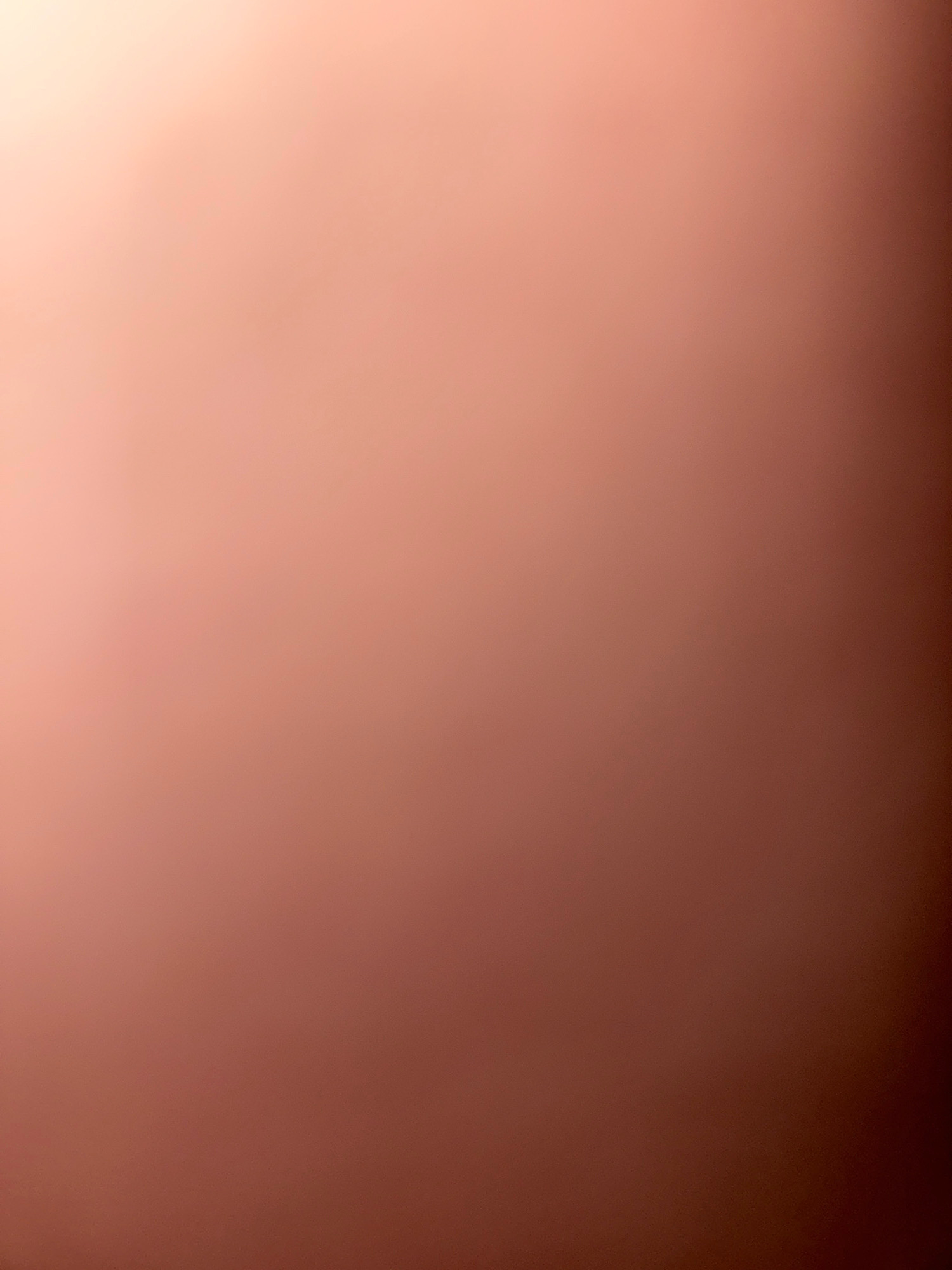 This is an abstract, out-of-focus image of a surface with a gradient of colors ranging from light peach at the top left to a darker reddish-brown at the bottom right. There are no discernible objects, people, or environmental features visible. The image provides no information about the city of Zavolzhye, Russia, or any specific scene.