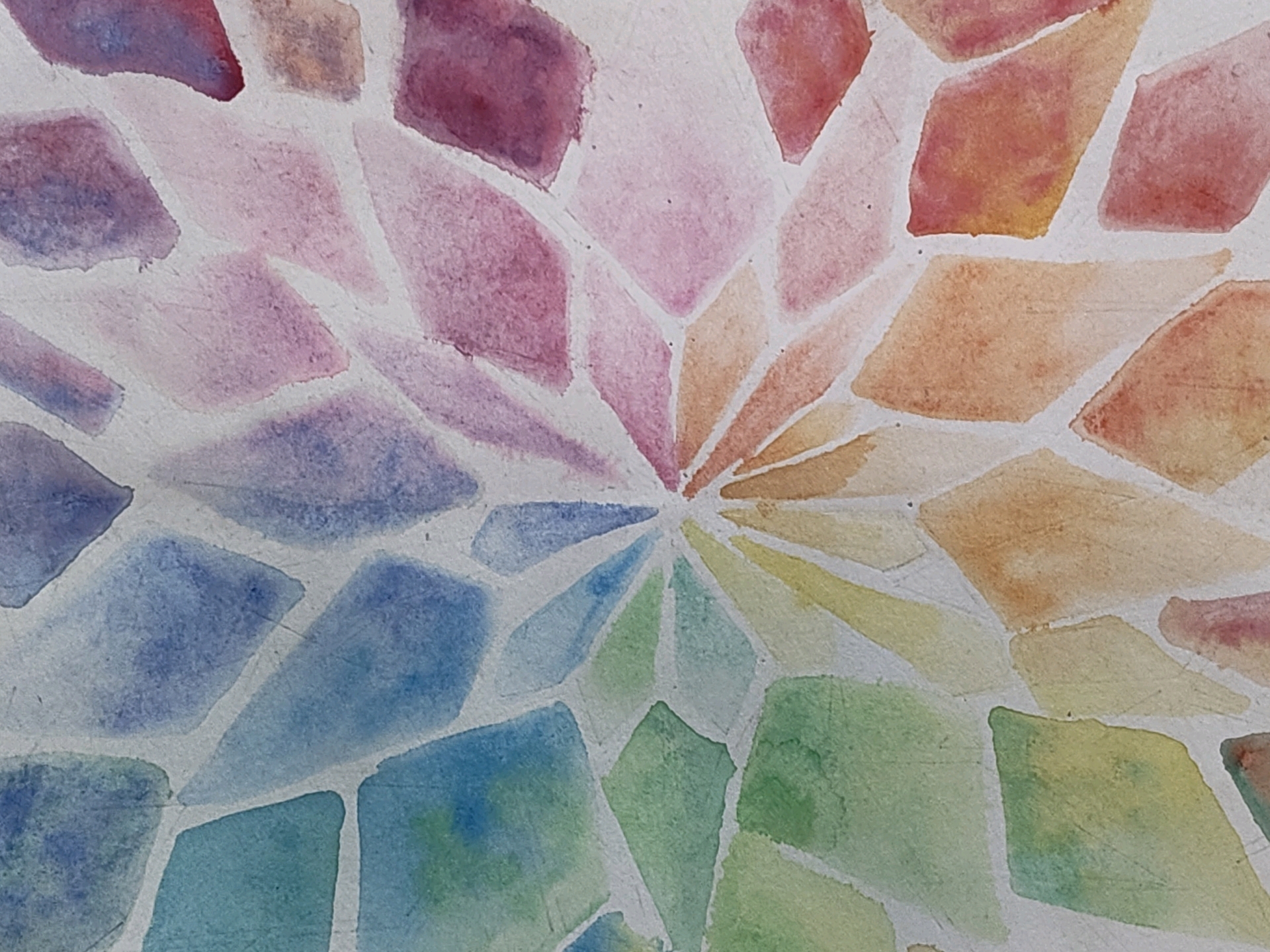 The image displays a close-up, overhead view of a watercolor painting featuring a mosaic-like pattern of diamond shapes in various soft, pastel colors. The colors transition from purples and pinks on the left, through blues and greens in the lower portion, to oranges and yellows on the right, all radiating from a central point. The white lines between the shapes suggest grout or the texture of the paper. There are no identifiable people, objects, actions, interactions, or environmental features from the city of Mysuru, India depicted in this abstract artwork.