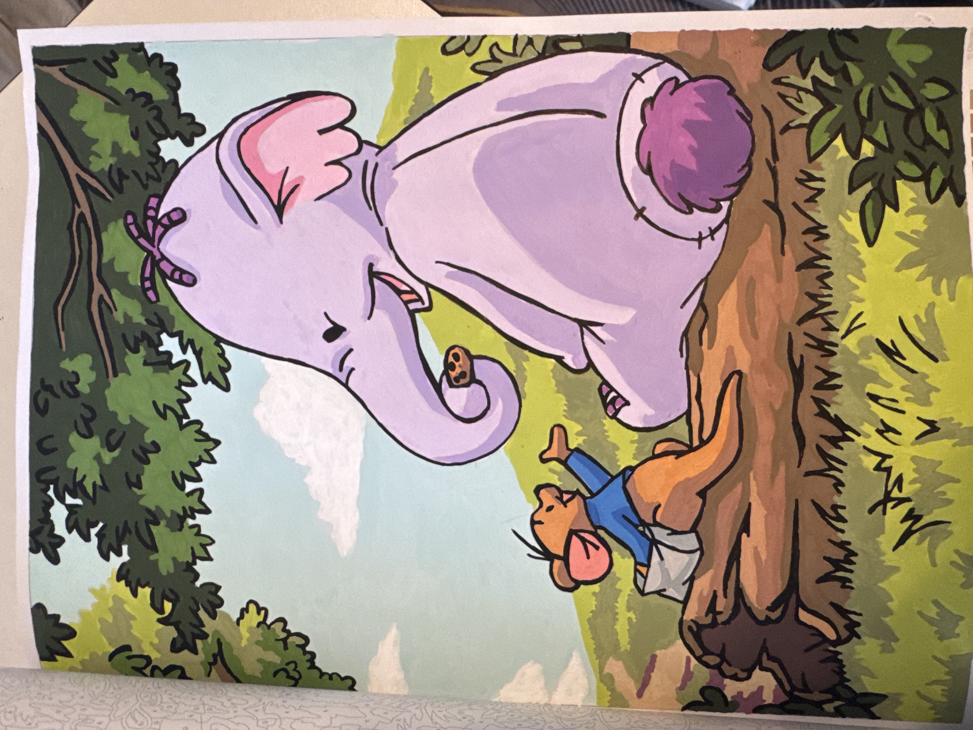 An illustration depicts an elephant with purple skin and pink ears sitting on a log. A small mouse wearing a blue shirt and white pants is standing on the log next to the elephant. The elephant is holding a cookie in its trunk. The background shows a green grassy hill, a blue sky with white clouds, and trees. The scene is outdoors in a natural environment.