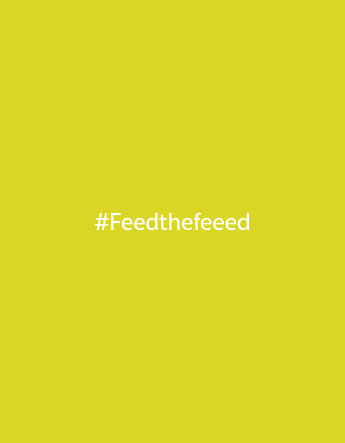 The image displays a solid, uniform yellow-green background. Centered on this background is white text, which reads '#Feedthefeeeed'. No people, additional subjects, objects beyond the text and background, actions, or environmental details are depicted. This scene is identified as being located in the city of Фоки, Russia.