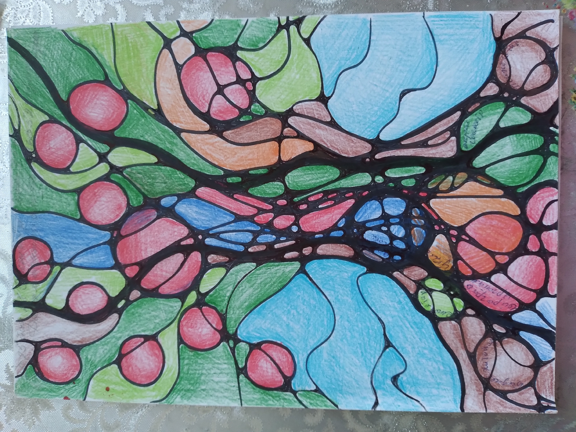 The image is a close-up, eye-level, colored pencil drawing on paper. The artwork depicts a stylized tree with organic, interconnected shapes in vibrant colors, including green, red, blue, and orange. The drawing features a central trunk-like structure branching out into various sections filled with circular and oval shapes, resembling fruits or leaves. The background is a textured, light-colored fabric, possibly a tablecloth. There are no people, actions, or interactions visible. The drawing does not depict any identifiable landmarks or scenes from the city of Baki, Uzbekistan.