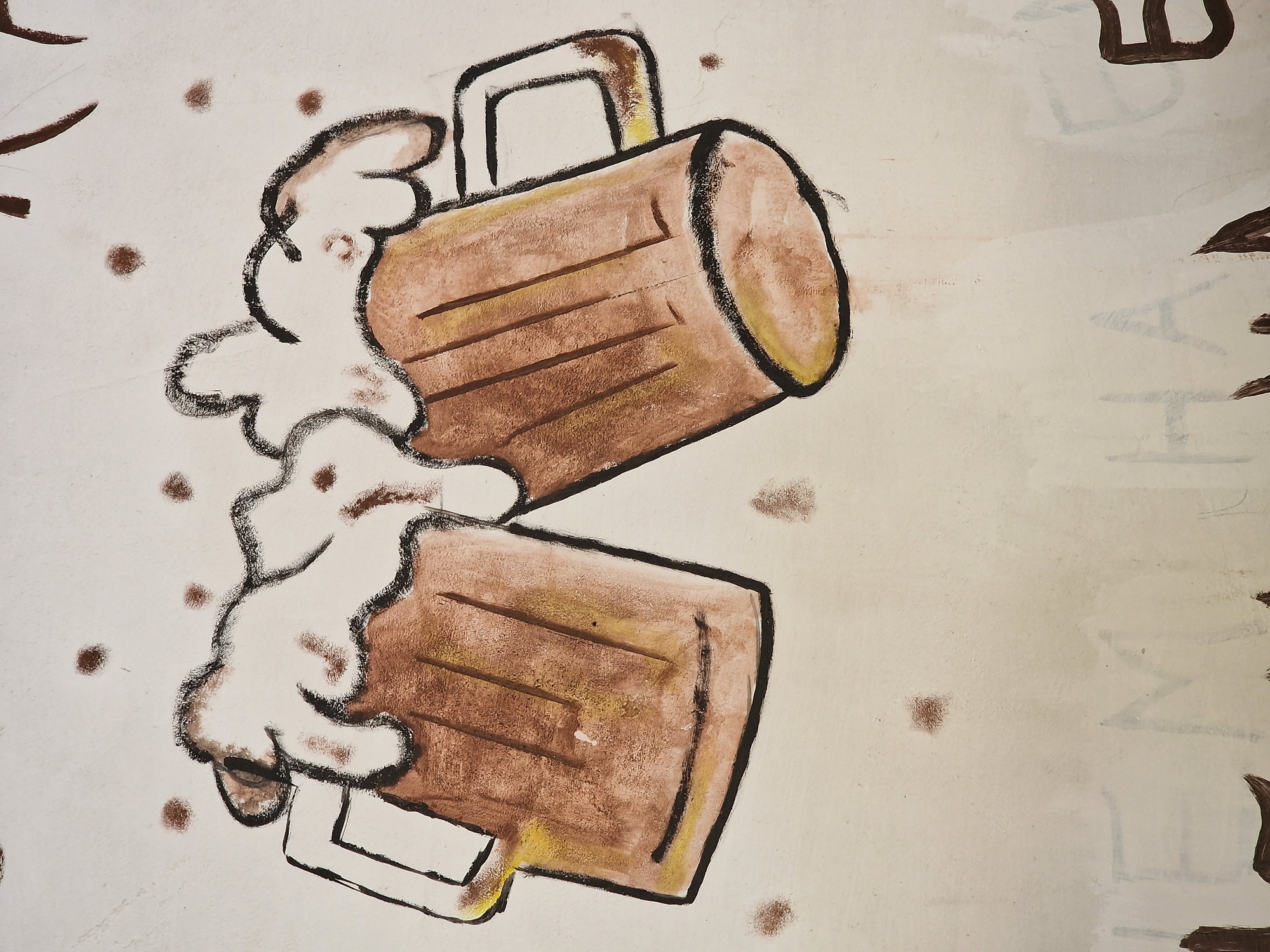 This is a photograph of a mural painted on a wall in the city of Shipka, Bulgaria. The mural depicts two frothy mugs of beer clinking together, rendered in a stylized, cartoonish manner. The beer mugs are brown with yellow highlights, and the foam is white and exaggerated. The background is a light color, possibly white or cream, with several small brown dots scattered around, resembling bubbles or specks of dirt. Some faint, smudged writing in what appears to be a lighter color is visible at the bottom of the image. The overall style is amateur, suggesting it might be a local artwork.