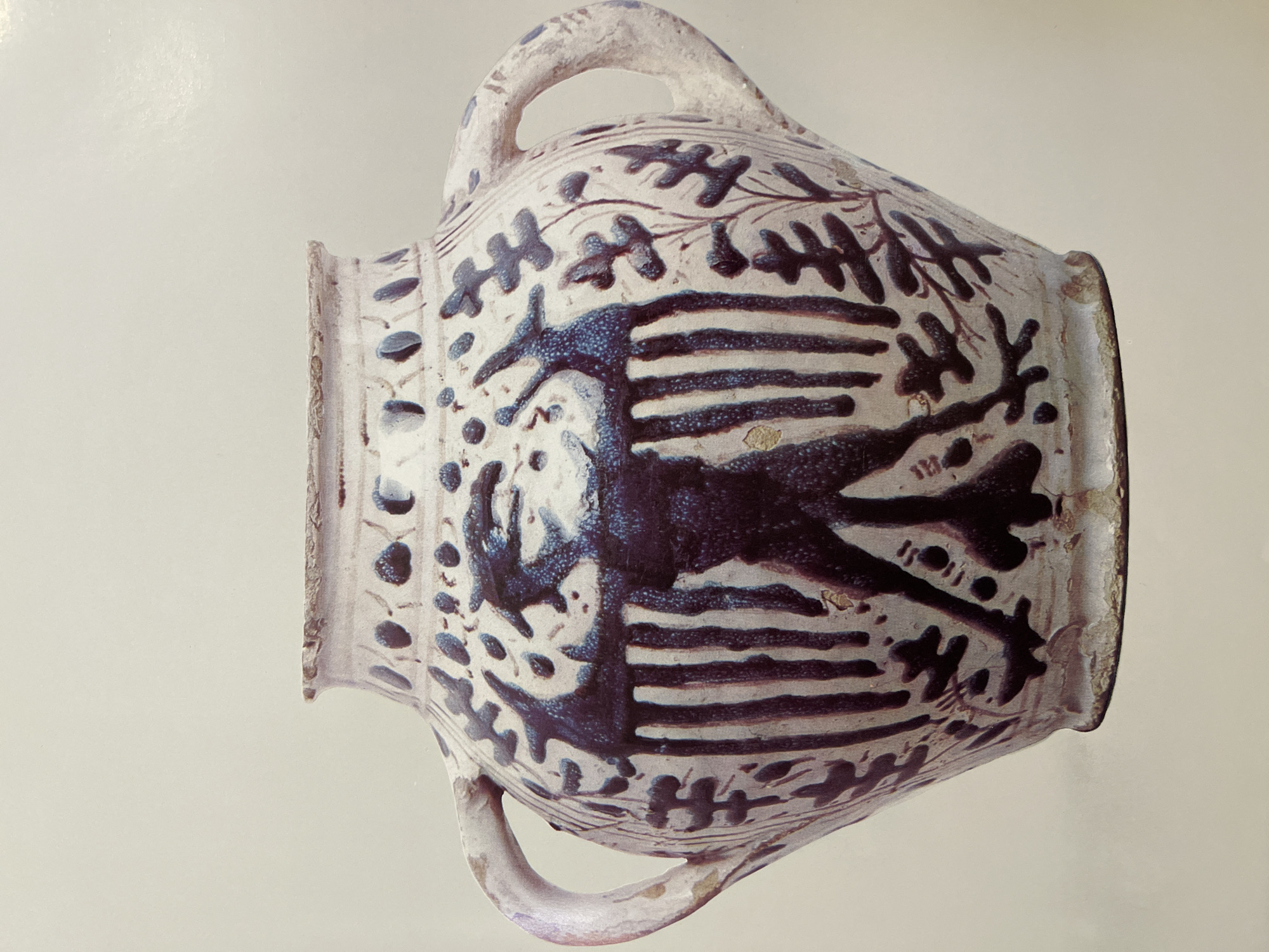 An earthenware albarello, or apothecary jar, decorated in blue with horizontal stripes, foliage and an animal, Unknown, Unknown. The jar is bulbous with two handles.
