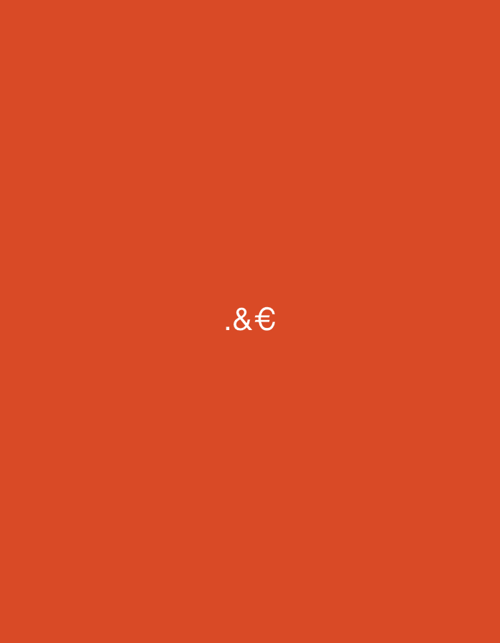 The image presents a minimalist graphic design with a solid, vibrant reddish-orange background (approximately RGB: 218, 69, 35). Centrally located, slightly below the vertical midpoint of the frame, are three white characters displayed in a plain, sans-serif typeface. These characters are, from left to right, a period (.), an ampersand (&), and a Euro symbol (€). The characters are static and form the sole subject matter. The environment is entirely abstract, consisting only of the plain colored background. There are no people, objects, actions, or specific environmental features present that would allow for the identification of a geographic location, thus precluding any determination of its presence in Casablanca, Morocco, or any other city.