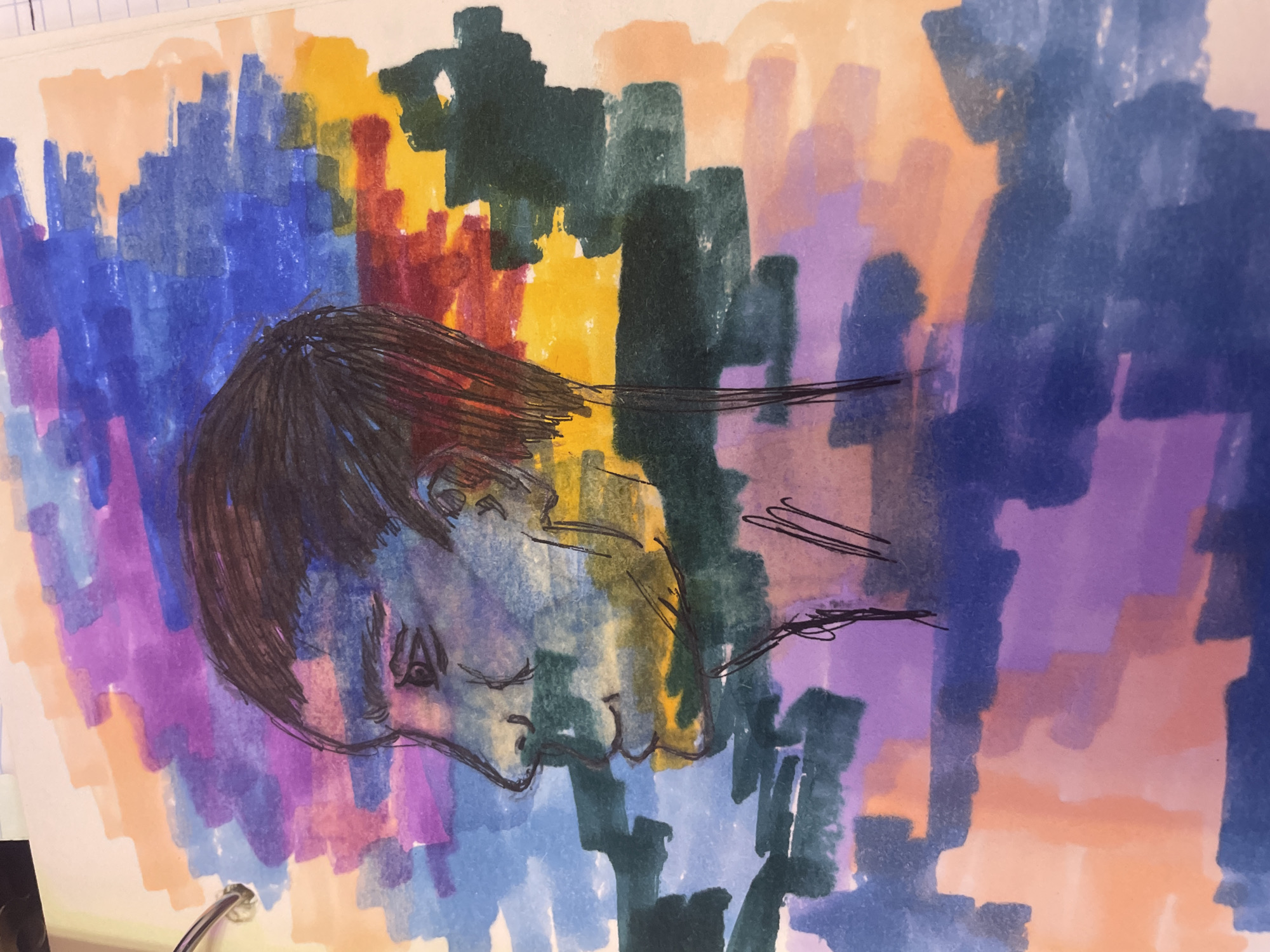The image is a close-up, overhead shot of a sketch of a person's profile rendered in black ink with vibrant marker coloring. The sketch depicts a person's head in profile, facing left, with a visible ear and hair. The coloring is abstract and blocky, featuring shades of blue, purple, orange, yellow, and green, applied in broad strokes behind and around the profile. The background appears to be a page from a sketchbook, with a metal binder ring visible at the top left corner. There are no identifiable elements within the image that suggest a specific location in the city of Sinyavino, Russia.