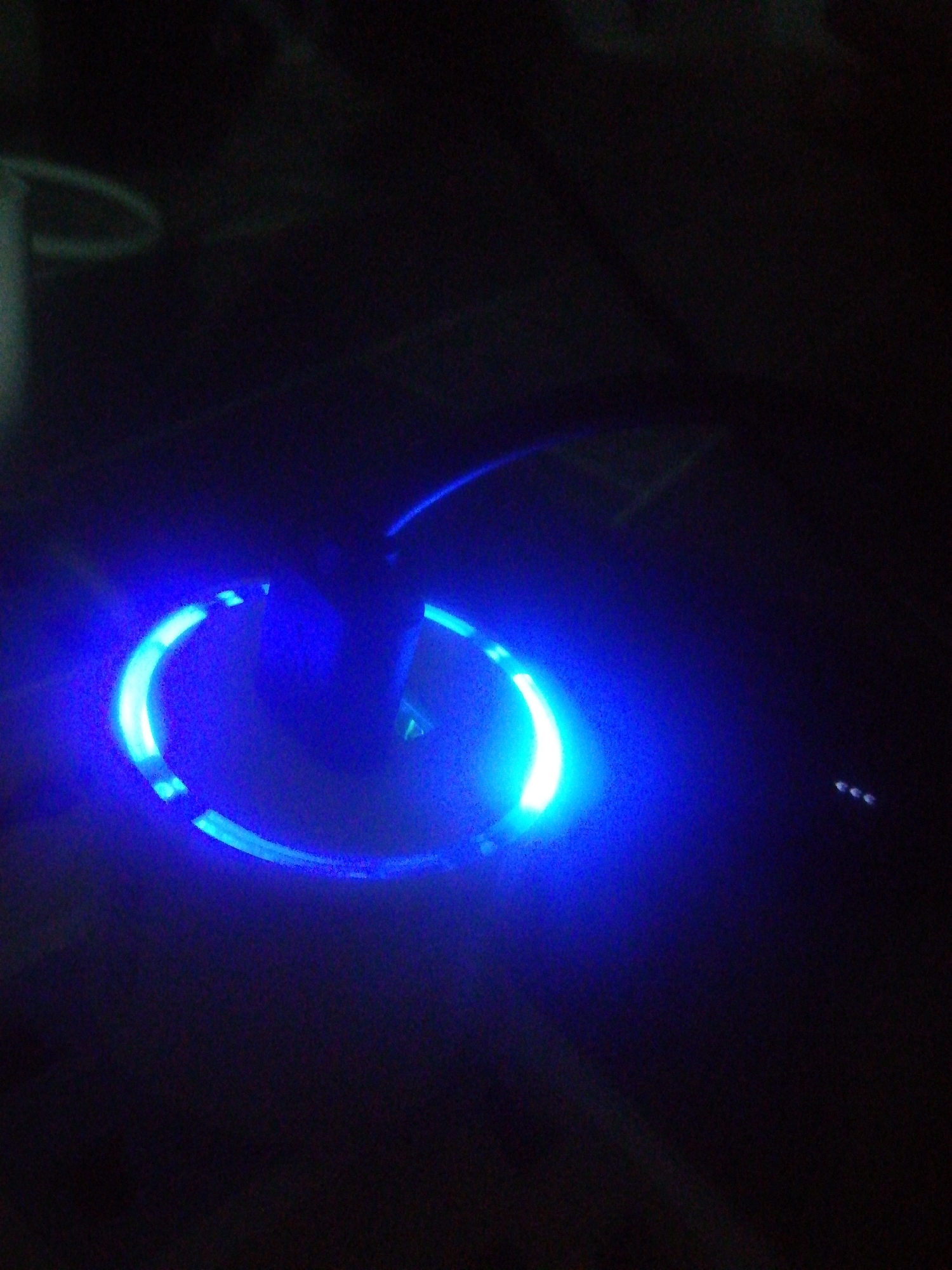 The image is a close-up, low-light photograph depicting a circular object emitting a bright blue light. The object appears to be a ring or a device with a circular illuminated section. The surrounding area is dark, suggesting a nighttime or dimly lit environment. The origin of the image in Ikorodu, Nigeria is unknown and cannot be ascertained from the image alone.