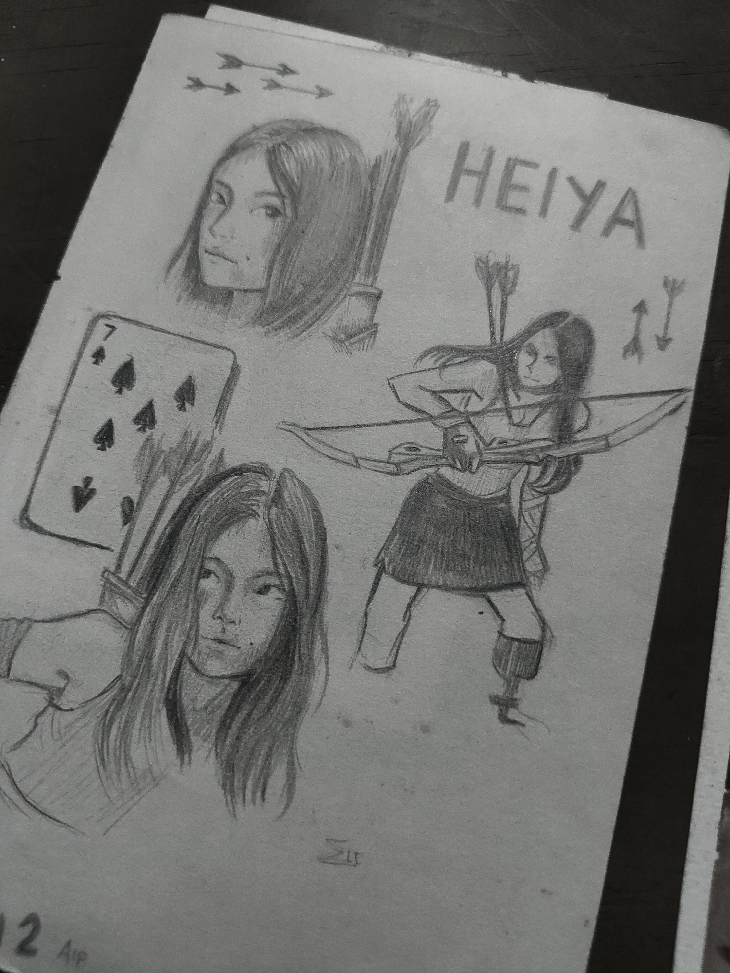 The image displays a pencil drawing on a light-colored paper sheet, presented at an angle on a dark, textured surface. The drawing features multiple sketches centered around a female character named "HEIYA," whose name is written in capitalized block letters in the upper right quadrant.
In the top-middle, a head-and-shoulders portrait of a woman with long, dark hair is depicted, looking to the viewer's right. Behind her right shoulder, a quiver filled with arrows is visible. Above this portrait, in the upper-left, three simple arrow symbols are drawn horizontally.
To the left of the central area, a playing card, the 7 of Spades, is sketched vertically. Below this card, another head-and-shoulders portrait of a woman with long, dark hair is presented, looking forward or slightly to the viewer's left.
The most prominent figure, in the center-right, is a full-body sketch of a woman, presumably Heiya, in a dynamic pose, aiming a recurve bow. She has long, dark hair and wears a top, a skirt, and boots. Arrows are visible near her and two separate arrows are drawn behind her, one pointing upward and one pointing downward.
A small, stylized signature or symbol is present below the central figure. In the bottom-left corner, partially visible text reads "12" and "AIP". The edges of the paper appear slightly worn or irregular.