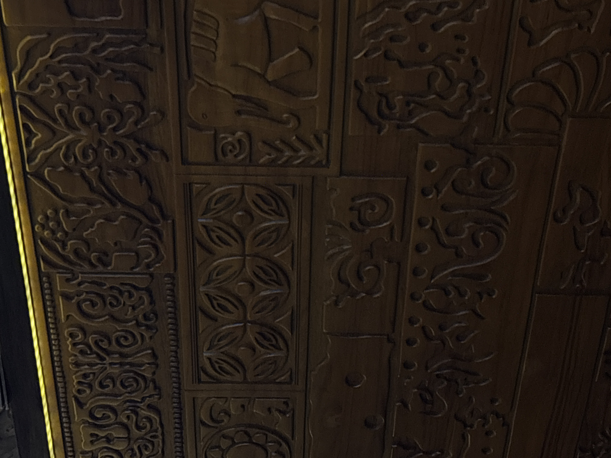 This image shows a close-up of a carved wooden ceiling or wall panel. The panels feature various decorative motifs. The setting or specific location in North Kuta, Indonesia, is not evident from the image. The image focuses solely on the detail of the carving.