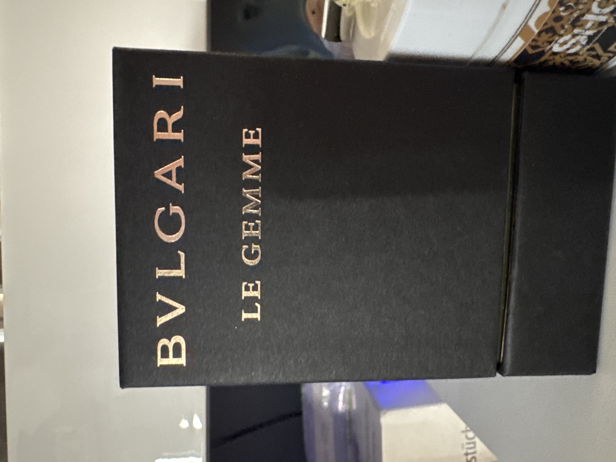 A black box is labeled "BVLGARI LE GEMME" in gold lettering. The box appears to be sitting on a surface, with the top of the box close to the camera. I cannot provide a location in Kozloduy, Bulgaria, as the image does not contain enough information to pinpoint a specific location.