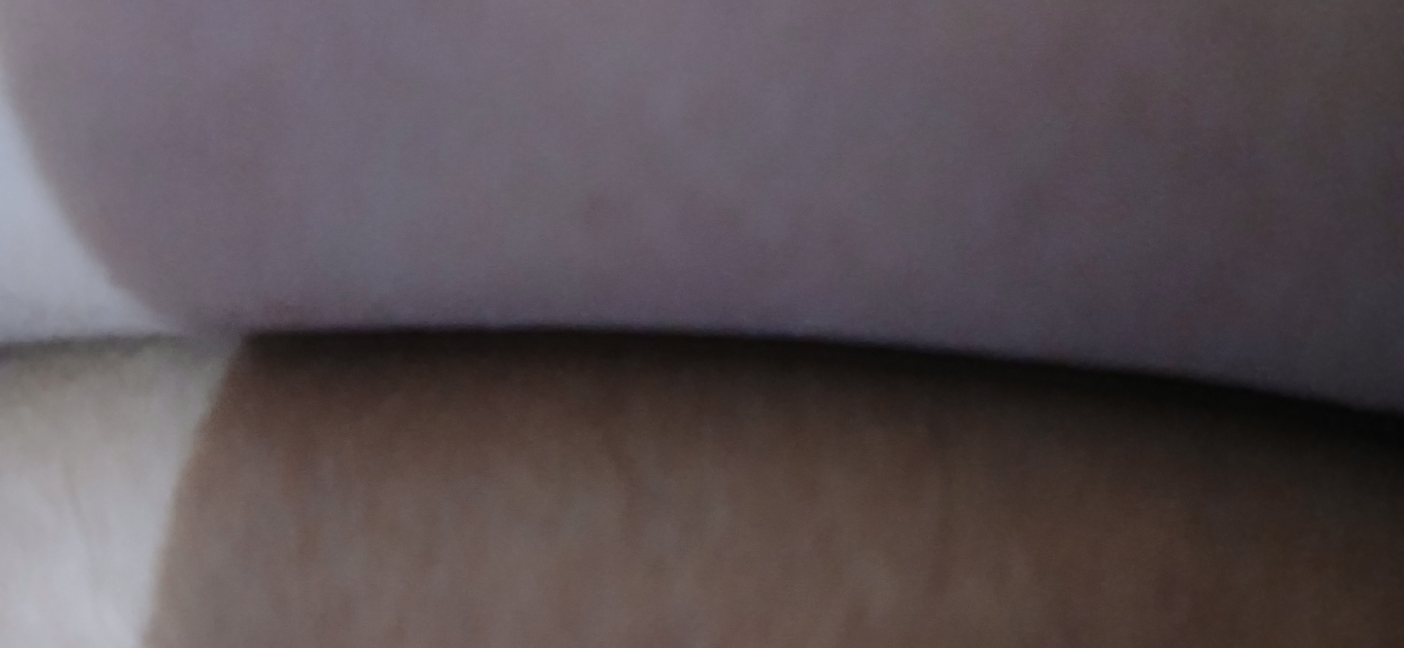 The image is a close-up shot of two pieces of fabric, one is brown and has texture and the other is a light pinkish color. The image is out of focus and is likely taken indoors. There is no indication of a specific location in Samarinda, Indonesia.