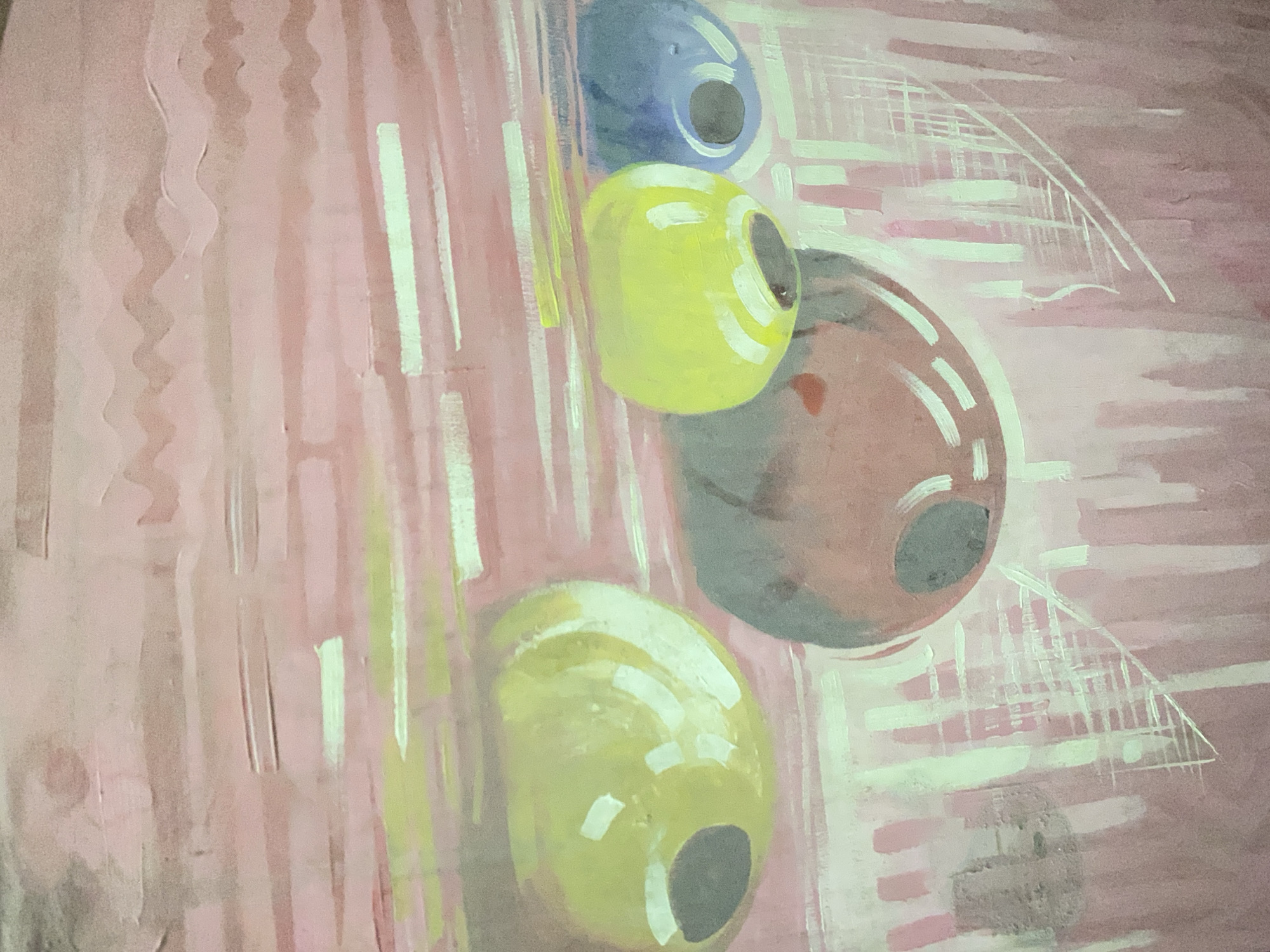 The image is a painting depicting olives. There are four olives arranged vertically, with a blue one at the top, followed by a yellow one, a brownish-red one, and another yellow one at the bottom. Each olive has a dark center, presumably the pit. The background is a pinkish-red color with vertical brushstrokes. There are also some white horizontal strokes that create a grid-like pattern. Some white lines also suggest a triangular shape in the background. There is no information in the image about the city of Gwagwalada, Nigeria, people, subjects, objects, actions, interactions, or the environment. The image only shows a painting of olives.
