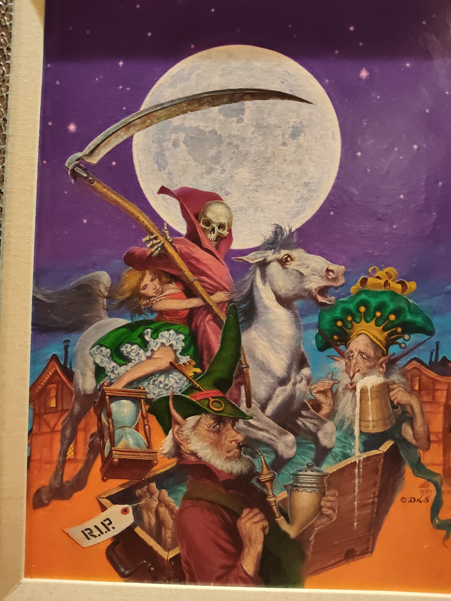 The image depicts a surreal, fantastical scene under a large full moon and a starry purple sky. The central figures include Death, personified as a skeletal figure in a red hooded robe, riding a white horse. A woman with blonde hair in a red and green dress is being carried by Death. In the foreground, a gnome-like character with a green hat and beard is smoking a pipe, while another character, also with a beard and wearing an elaborate green and gold hat, drinks from a large mug of ale. An hourglass is visible, along with a tag that reads "R.I.P." and an open box containing feet. The background features stylized buildings that resemble quaint houses or shops. The overall mood is dark fantasy. The image is a painting, and a signature appears in the lower right corner, reading "© D.K.S." There is no indication of this scene being located in Singapore, Singapore.
