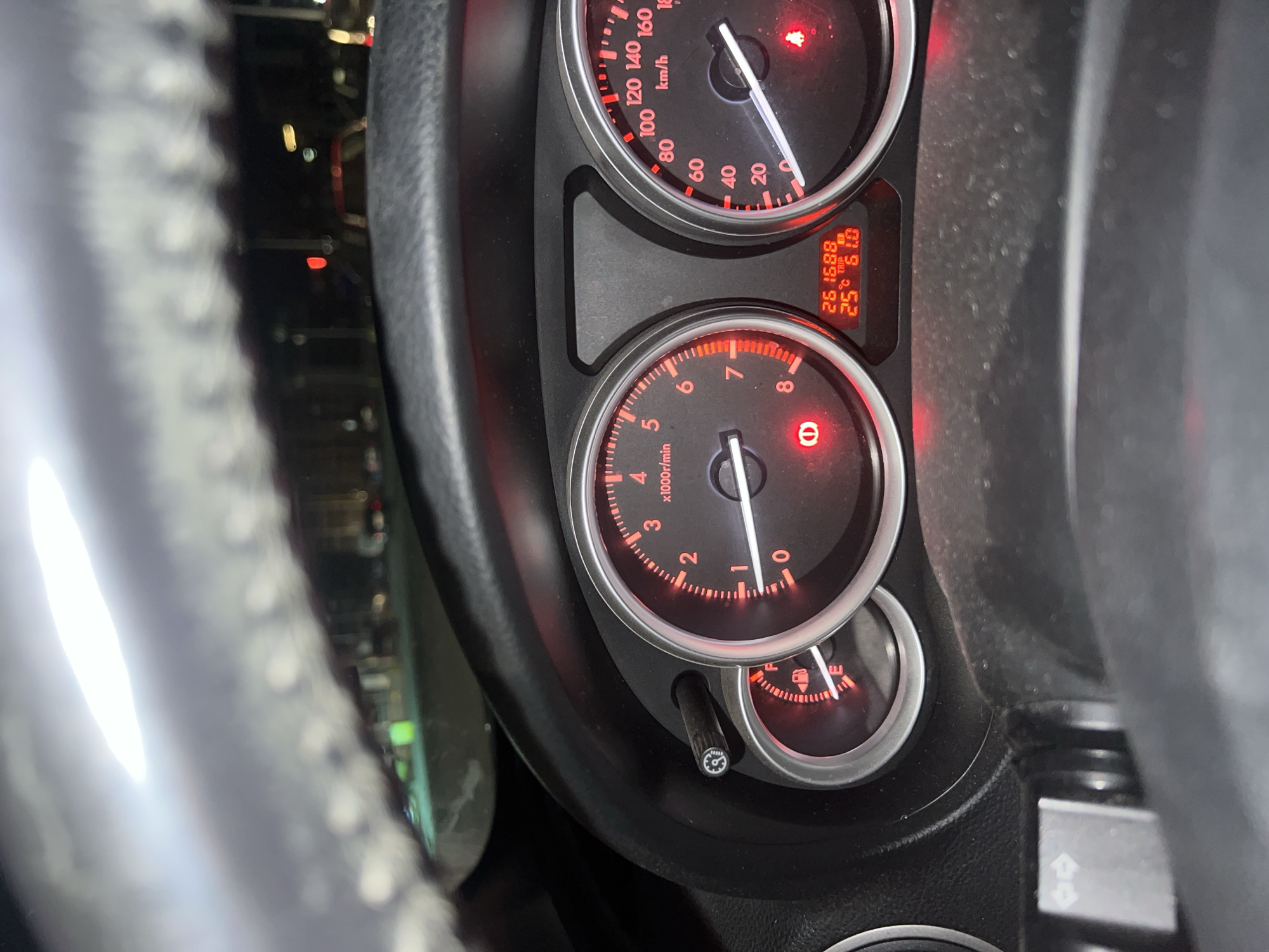 The image shows the dashboard of a car. The speedometer reads approximately 10 km/h. The tachometer reads near 0 RPM. The odometer shows 261688 km. The trip meter reads 61.0 km. The ambient temperature is 25 degrees Celsius. The fuel gauge indicates the fuel level is near empty. A steering wheel is visible. The location (Burgas, Bulgaria) cannot be inferred from the image.
