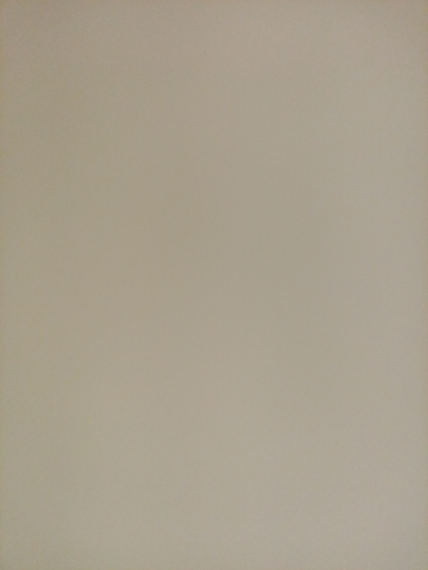 This is a full-frame, eye-level shot of a plain, beige wall in Rostov-on-Don, Russia. The wall appears to be made of plaster or a similar material, with a subtle texture visible upon close inspection. There are no objects, people, or any distinguishing features present in the image. The lighting is even, suggesting a diffused light source, possibly an overcast day or an indoor environment without direct sunlight. The color is a neutral, desaturated beige, offering no specific clues about the location beyond its general appearance as a wall.