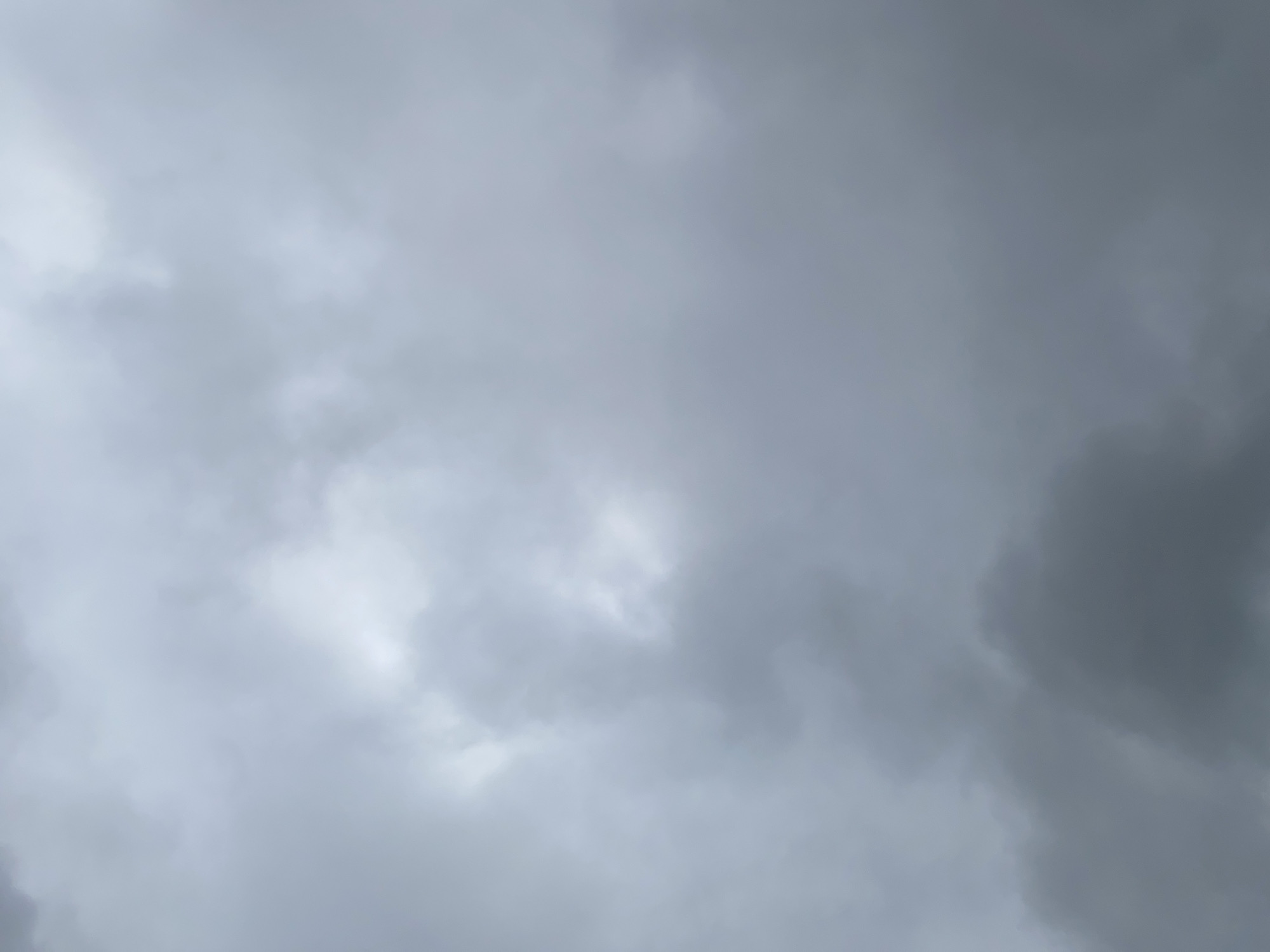 The image shows a cloudy sky over Lafia, Nigeria. The clouds are dark and heavy, suggesting an impending storm. There are no people, subjects, objects, or actions visible in the image. The environment is solely the sky, with no discernible features of the city below. The focus is entirely on the atmospheric conditions.