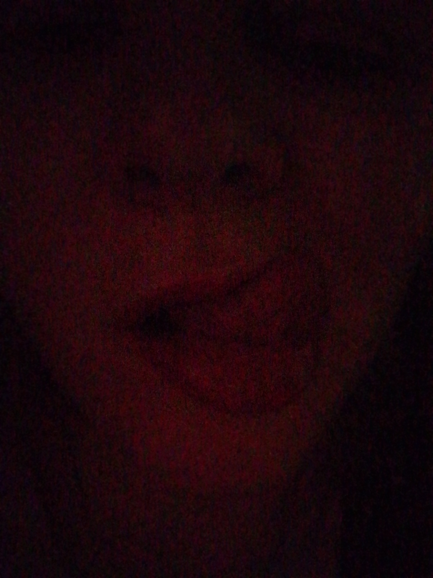 The image appears to be a dimly lit portrait of a person. The face is visible, with identifiable eyes, nose, and mouth. However, the lighting is very poor, and the details are obscured. There is no information about Izhevsk, Russia, or any other location.