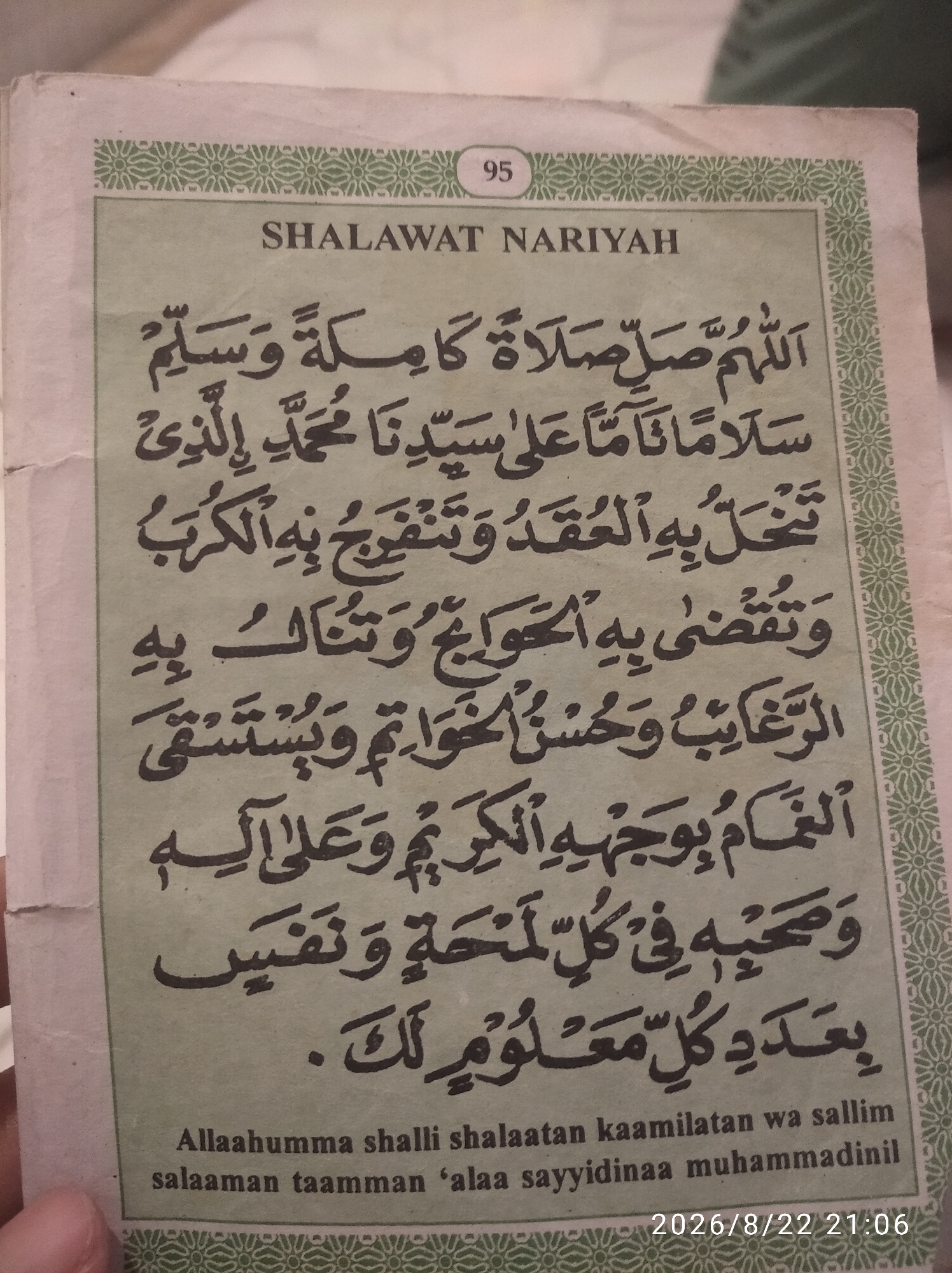 The image shows a page from a book titled "SHALAWAT NARIYAH" with the number "95" at the top. The text is in Arabic script and appears to be a prayer or invocation, followed by a transliteration in English at the bottom of the page. The page has decorative borders. There is no visible indication of the city of Nglebak, Indonesia. The image is a close-up shot of the book page, with no people or environmental context visible beyond the text and borders of the book itself. The bottom right corner displays a timestamp "2026/8/22 21:06".