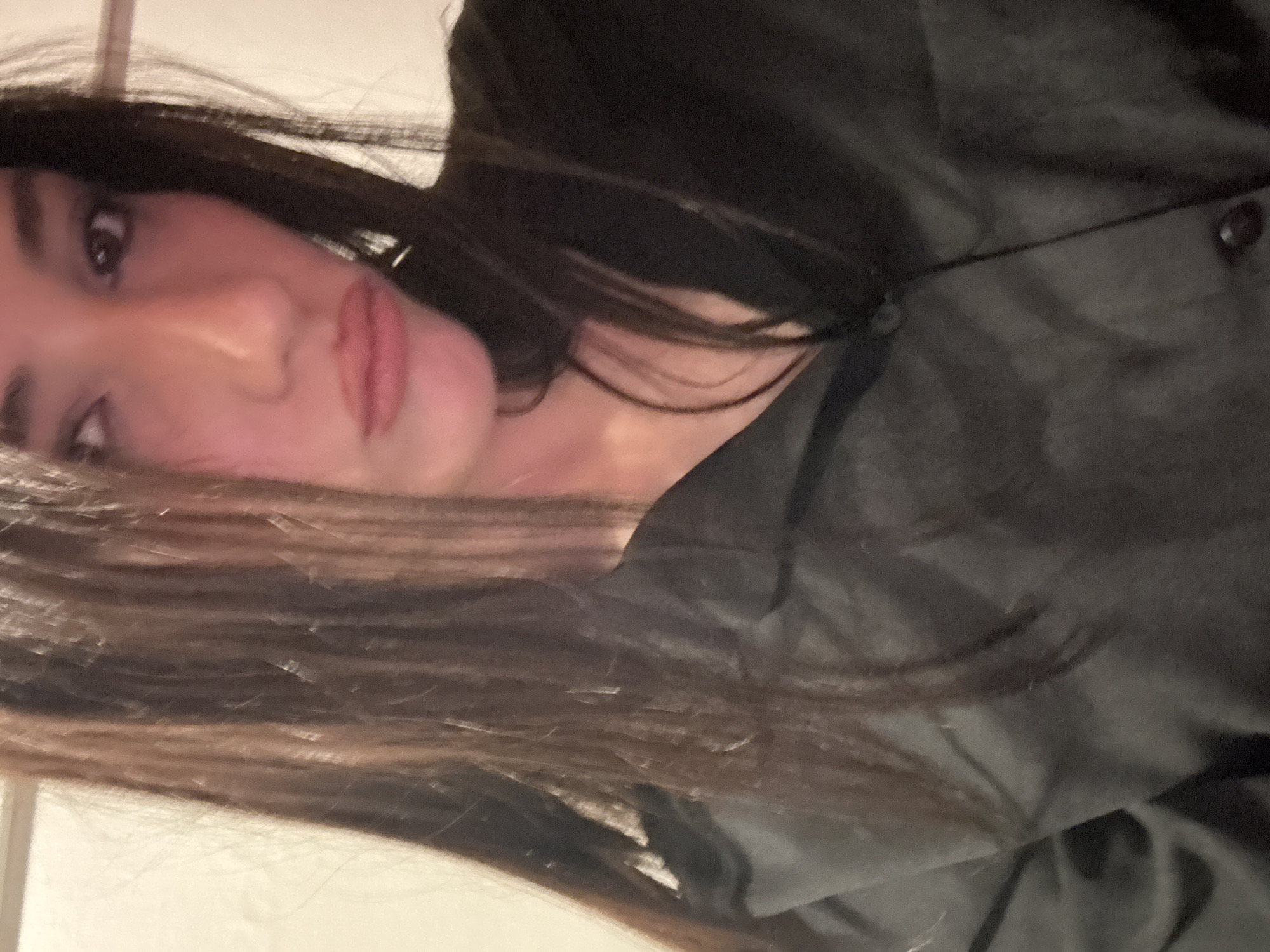 A woman with long brown hair is visible from the chest up. She is wearing a dark-colored, buttoned shirt or jacket. Her face is partially obscured by her hair. No information is provided in the image to determine a location in Buenos Aires, Argentina, or any other specific location.