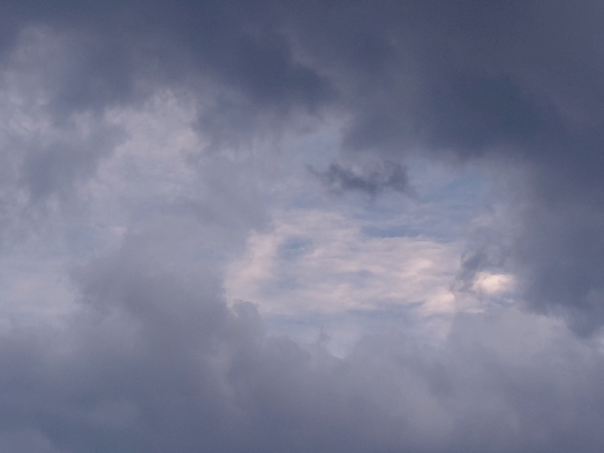 The image depicts a cloudy sky with varying shades of grey and white. There are patches of lighter sky visible through the denser clouds, suggesting a break in the overcast conditions. The clouds are textured and appear to be in motion. No specific landmarks or elements of the city of Samara, Russia, are identifiable in this image. The scene is entirely focused on the atmospheric conditions.