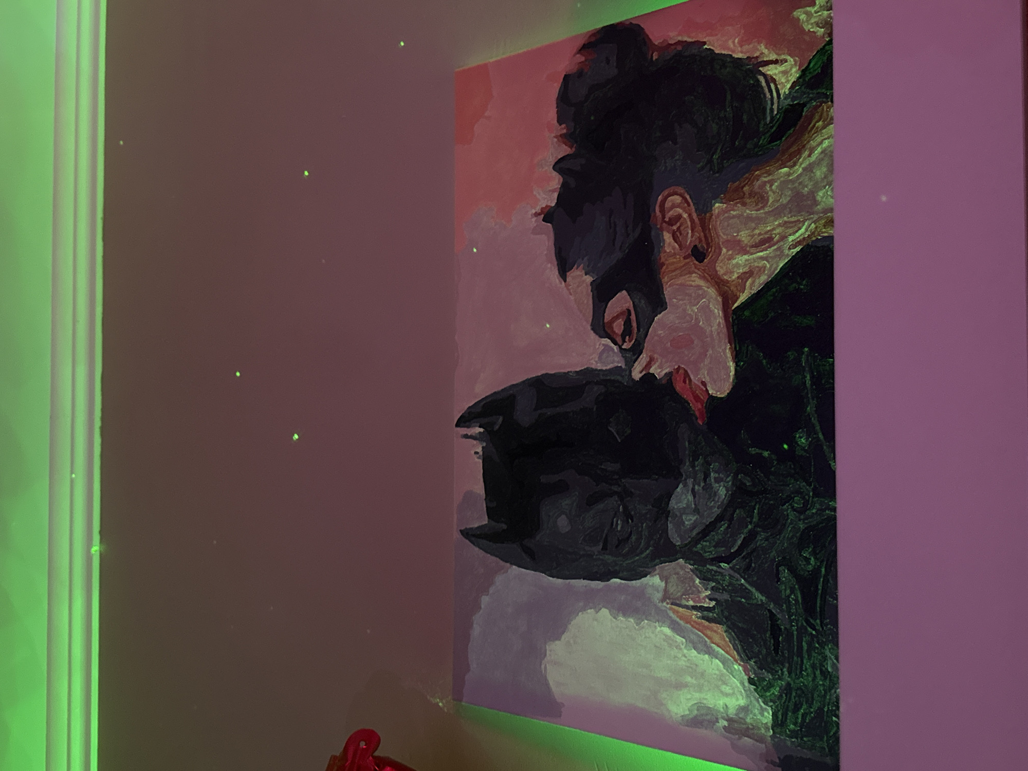 The image depicts an oil painting of Batman and Catwoman embracing. The painting is mounted on a wall in a room with pink and purple walls. A strip of green lighting is visible along the edge of a wall. The location is Unknown, Unknown.