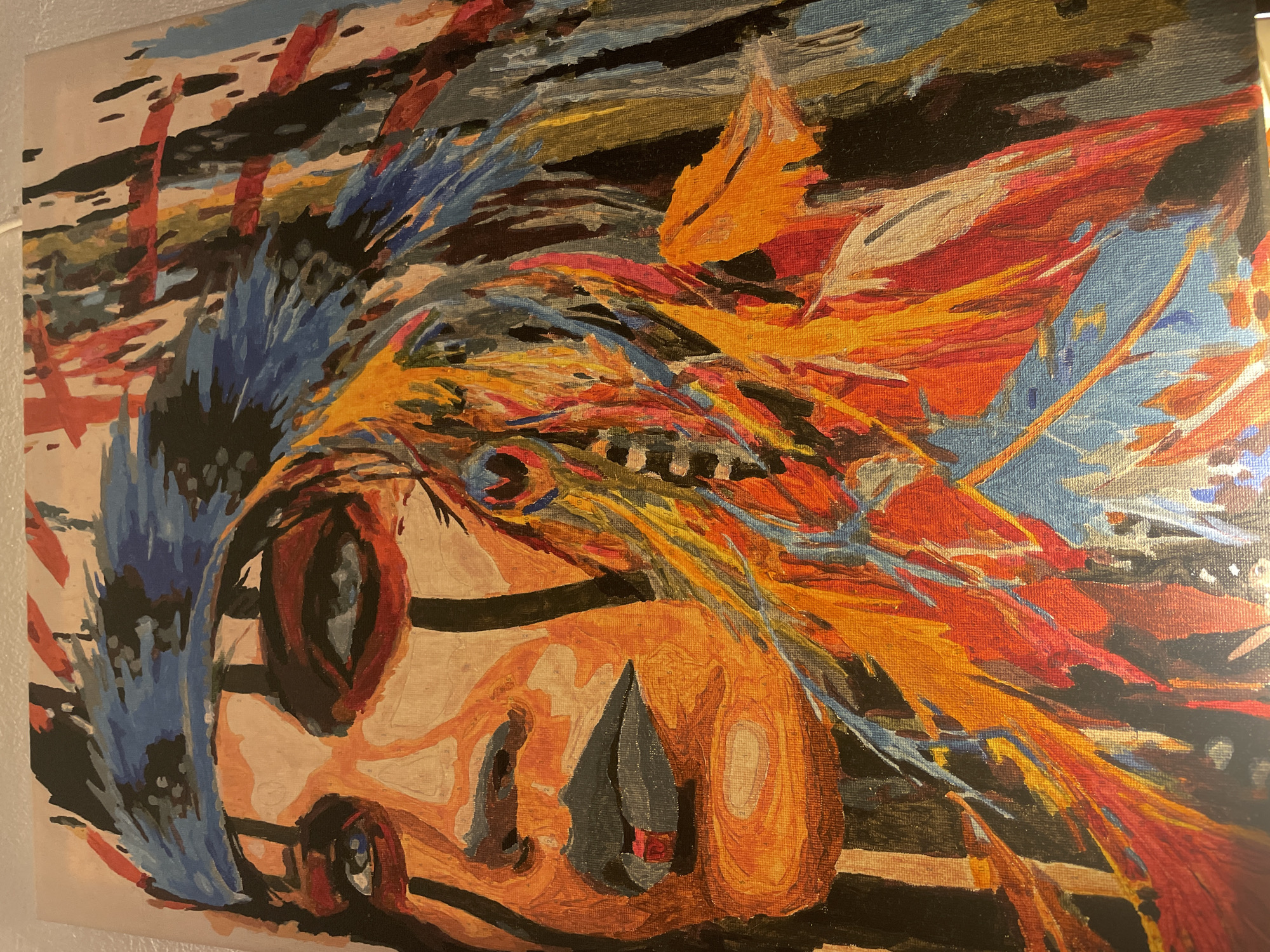 The image is a close-up of an abstract painting. The subject appears to be a face with colorful, expressive brushstrokes forming the hair and background. Predominant colors include blue, orange, red, and black. The face is peach-colored with dark outlines and features. The painting is on canvas. There is no discernible location of Sofia, Bulgaria.