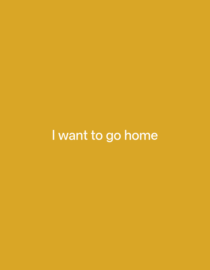 A plain image displays the text "I want to go home" in white, sans-serif font against a solid, warm yellow background. The text is centered horizontally and vertically within the frame. No other subjects, objects, activities, or contextual details are present in the image.