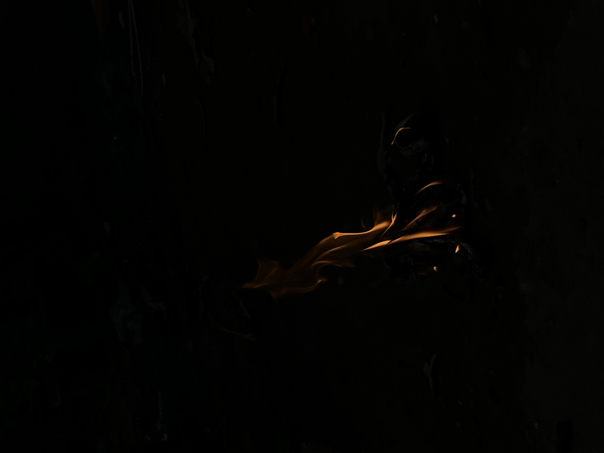 The image shows flames in the darkness. The environment surrounding the flame cannot be made out, but the darkness suggests a night scene in Lokoja, Nigeria. There are no visible subjects, actions, or interactions.