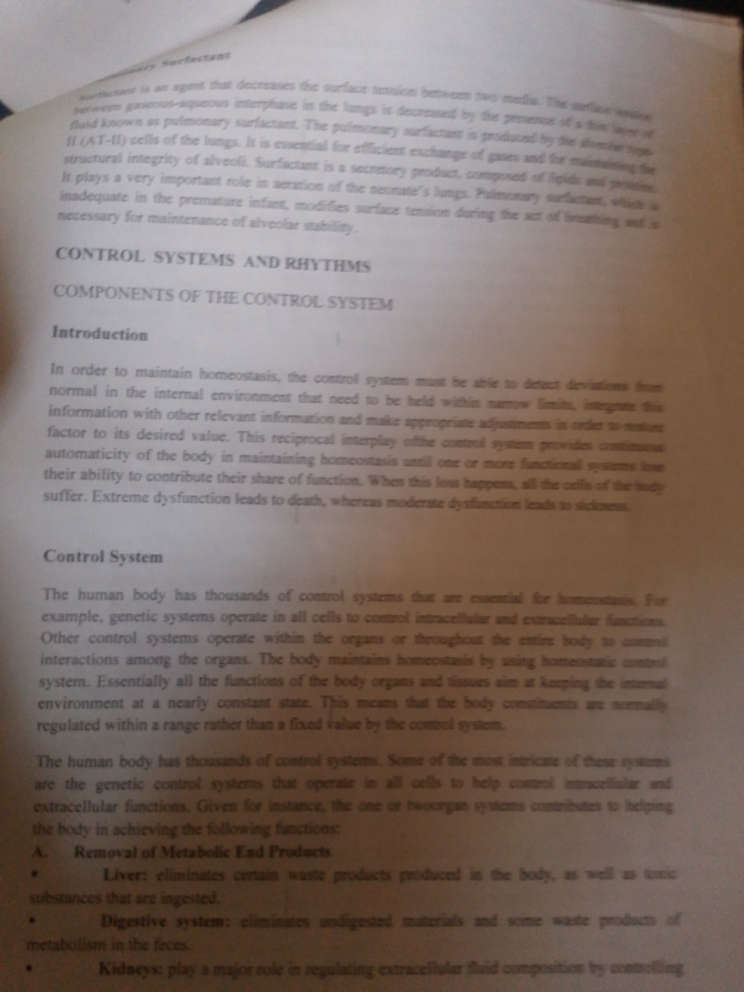 The media file is a photograph of an open book, focusing on a page with text. The subject is the content of the book, specifically a section on biological control systems. The text discusses concepts like "surfactant," "pulmonary surfactant," "homeostasis," and "control systems" within the human body. It details the functions of organs like the liver, digestive system, and kidneys in maintaining bodily equilibrium. The page is well-lit, suggesting an indoor setting with adequate lighting, possibly a library or study area. There are no people or specific objects other than the book itself. The visible text is primarily in English and appears to be from a biology or physiology textbook. The overall mood is informative and academic. The photograph is taken from a slightly angled perspective, capturing the texture of the paper and the printed text. There are no discernible location cues for Jalingo, Nigeria within the image itself, nor any information about the time of day or weather. The focus is solely on the printed content of the book.