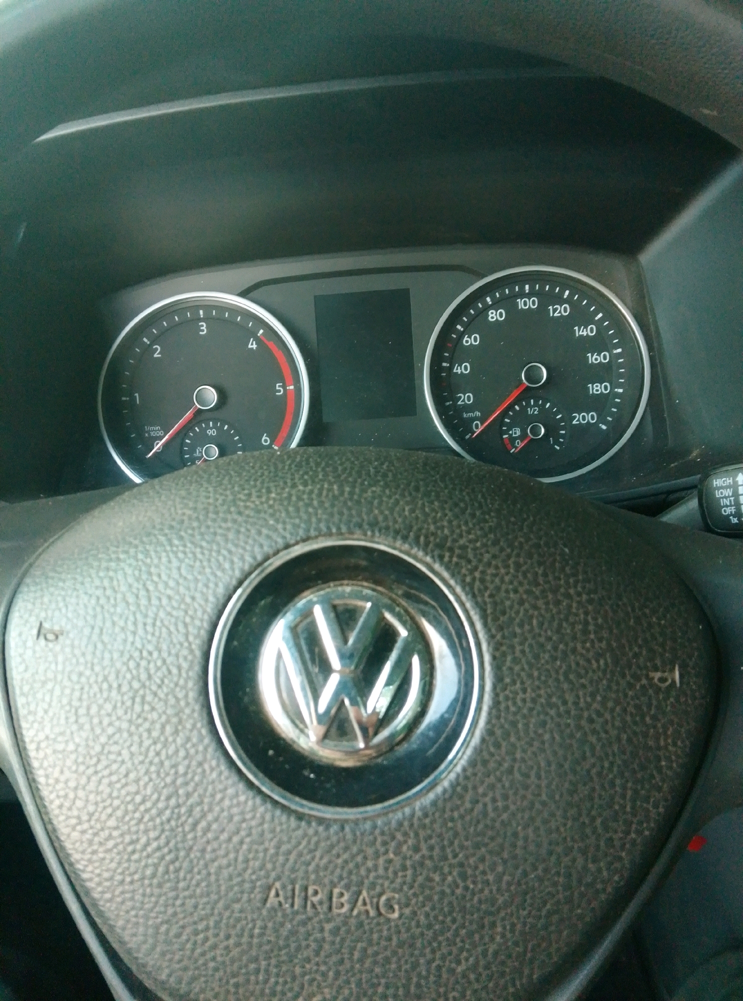 A close-up interior shot of a car shows a steering wheel with a Volkswagen logo in the center and the word "AIRBAG" printed below it. The dashboard features a tachometer on the left, indicating approximately 1,000 RPM, and a speedometer on the right, showing about 20 km/h. The image is captured from a low angle, looking up towards the dashboard and steering wheel. The lighting suggests it is daytime, possibly with sunlight filtering in. There is no indication of the city of Wedel, Germany within the image.