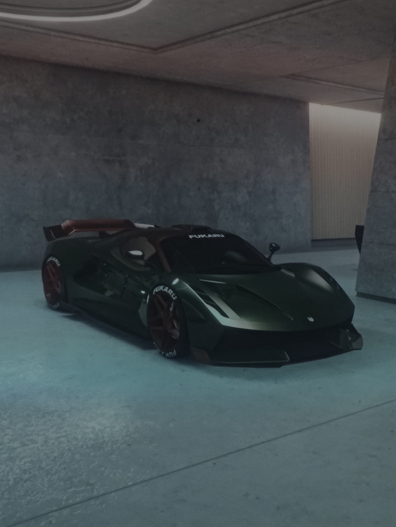 The image features a sleek, dark metallic green sports car or supercar parked within an enclosed, concrete setting, resembling a modern garage or showroom. The car has a low-slung, aerodynamic design with prominent red-brown or bronze multi-spoke alloy wheels. A large rear spoiler, matching the wheel color, is visible. White lettering spelling "FUKARU" is clearly displayed on the sidewalls of all visible tires, as well as along the top edge of the car's windshield.
The environment is characterized by textured, grey concrete walls and a matching concrete floor with visible seams. The lighting is dim and artificial, creating a cool, bluish tint across the scene. In the background to the right, a lighter, vertically ribbed wall or panel is partially visible, illuminated from above. There are no people present, and the car appears to be stationary. The overall aesthetic, including the slight blur and color saturation, suggests that the image is likely a digital render or a screenshot from a video game rather than a photograph of a physical object. The provided location context of Ipswich, United Kingdom, cannot be visually confirmed from the elements within this digitally-rendered scene.