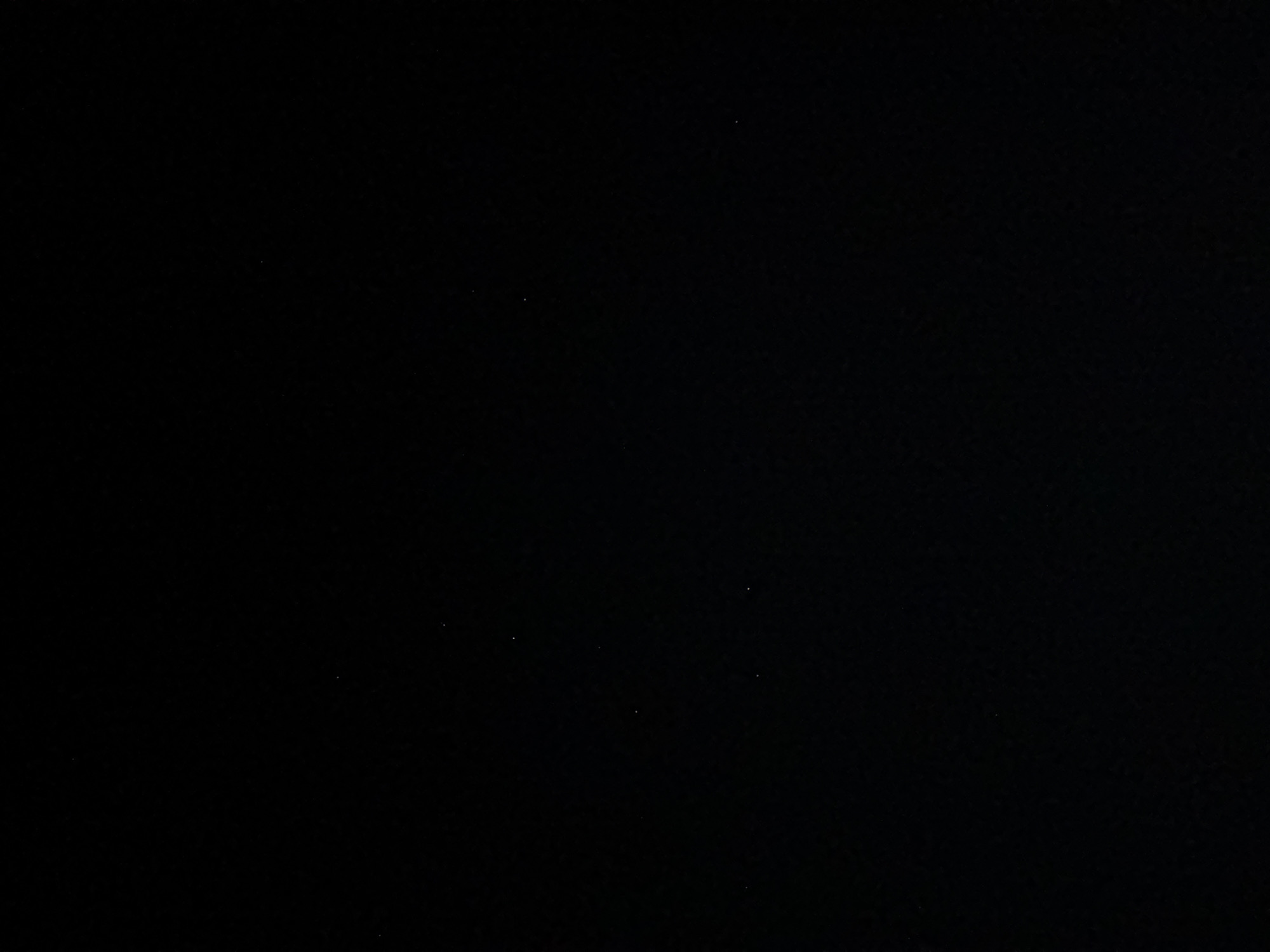 The image is a black screen with a few faint white specks, possibly stars or dust. No discernible objects, people, or environment are visible. The location in Taganrogskii, Russia cannot be determined from the provided image.