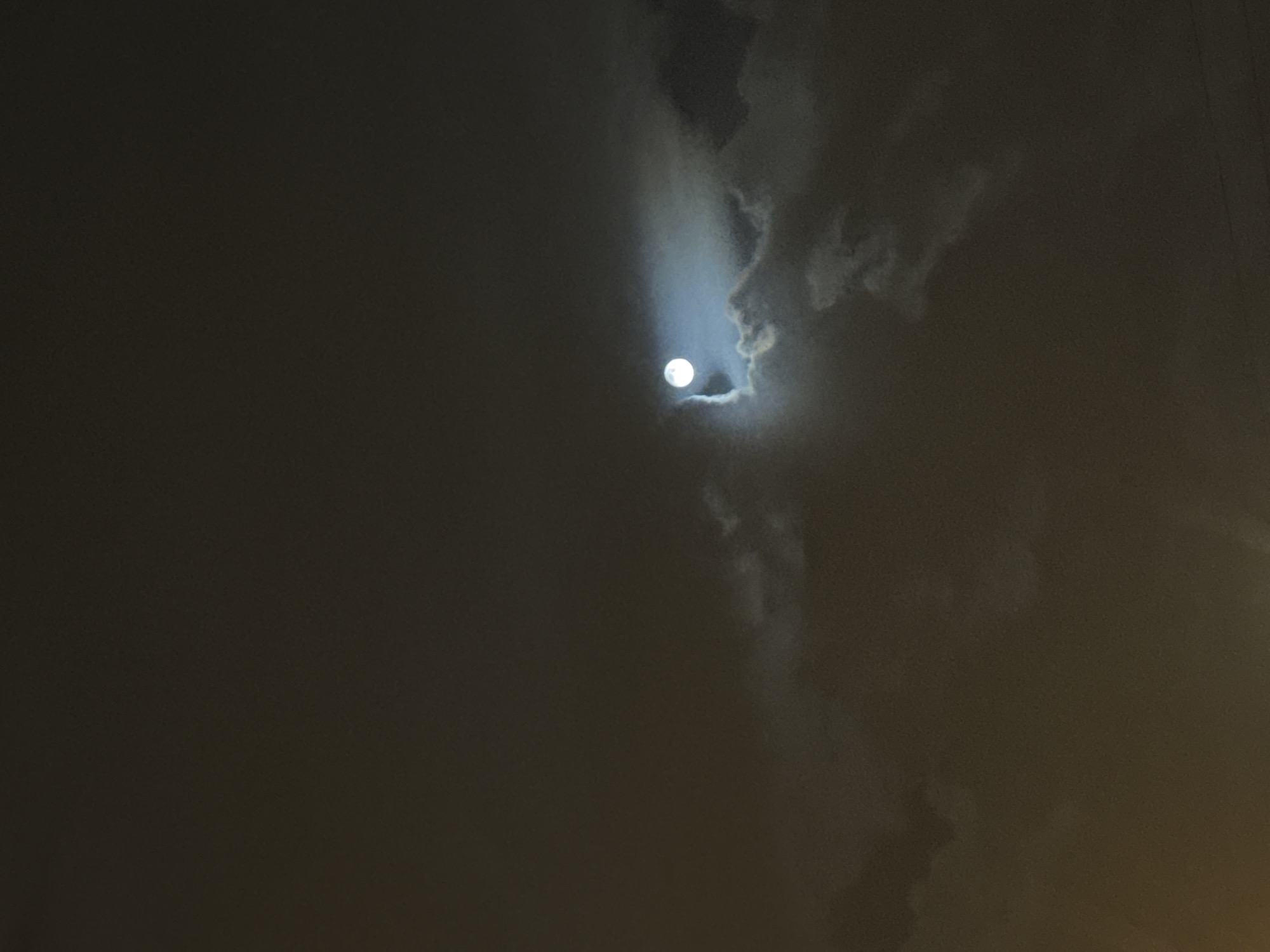 A full moon is visible through a break in heavy clouds. The scene appears to be taken at night. Moscow, Russia is not evident in the image.