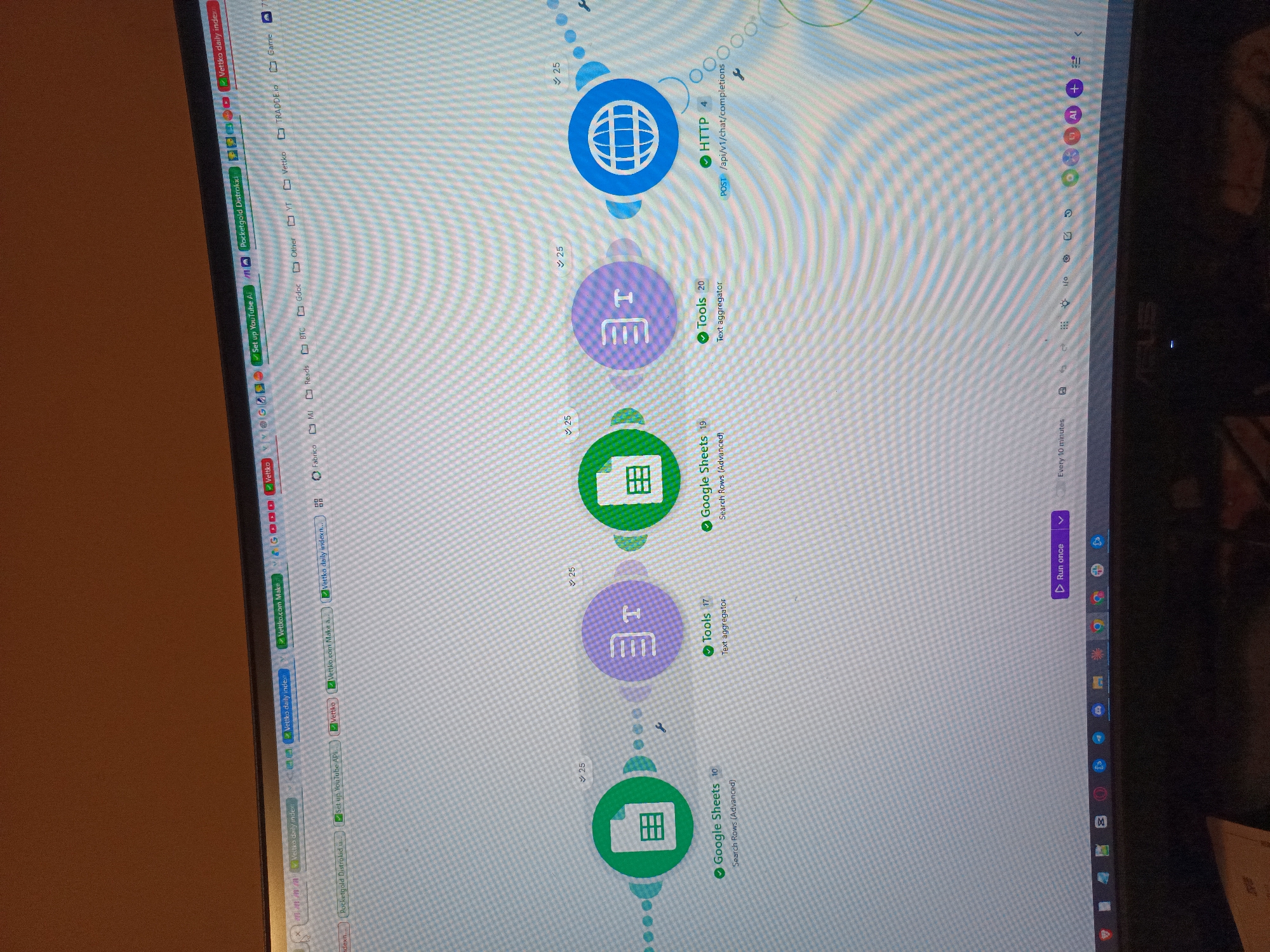 The image shows a computer screen displaying a data workflow diagram. The workflow consists of a sequence of connected nodes. The first node, labeled "HTTP 4", has a globe icon and points to a POST request to "/api/v1/chat/completions". This node is connected to a "Tools 20" node labeled "Text aggregator." This node is then connected to a "Google Sheets 19" node, labeled "Search Rows (Advanced)," which connects to another "Tools 17" "Text aggregator" node. Finally, a "Google Sheets 10" node is at the end, also labeled "Search Rows (Advanced)." The screen also shows browser tabs along the top and side, including "Vettko daily index" and "Pocketgold Distrokid." A menu on the right side shows options like "Run once" and a schedule of "Every 10 minutes." The environment is a typical home or office setting with a desk and computer. The location of the scene in Sofia, Bulgaria, cannot be determined from the image alone.