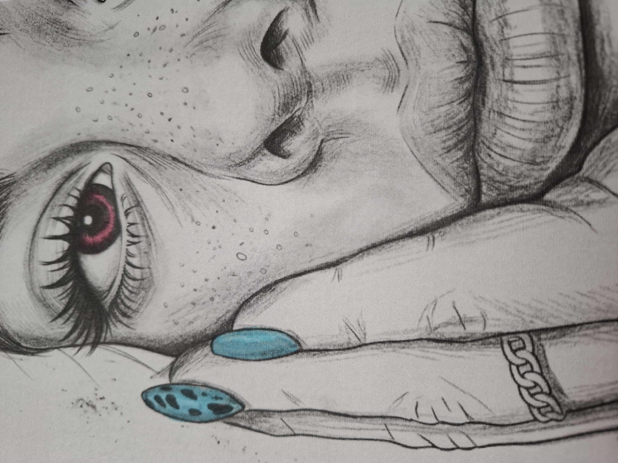 The media file presents a close-up photograph of a stylized drawing, likely from an art book or coloring page. The image focuses on the upper left portion of a human face and a hand, rendered in a detailed line art style with selective coloring.
The visible part of the face includes the forehead, the left eye, part of the nose, and the area above the upper lip. The eye features long, dark eyelashes and a striking red iris, while the gaze is directed downwards, conveying a sense of introspection or calm. Numerous small dots, consistent with freckles or skin texture, are visible across the skin areas.
A hand is positioned gently against the face, with three fingers prominently displayed. The fingernails are painted in a vivid teal or turquoise color. One nail, on the ring finger, features a distinctive black spotted pattern. A chunky ring, designed as interconnected links or a braided chain, is worn on one of the fingers.
The drawing is characterized by its clean lines and attention to detail. The background is plain, emphasizing the subject. The overall texture of the image, visible in the fine dot pattern, suggests it's a printed artwork photographed, possibly on a page with a slight fabric-like grain. No specific activity is depicted other than the thoughtful pose. There is no visible text in the image. The context of Burgas, Bulgaria, is not indicated by any visual cues within the artwork.