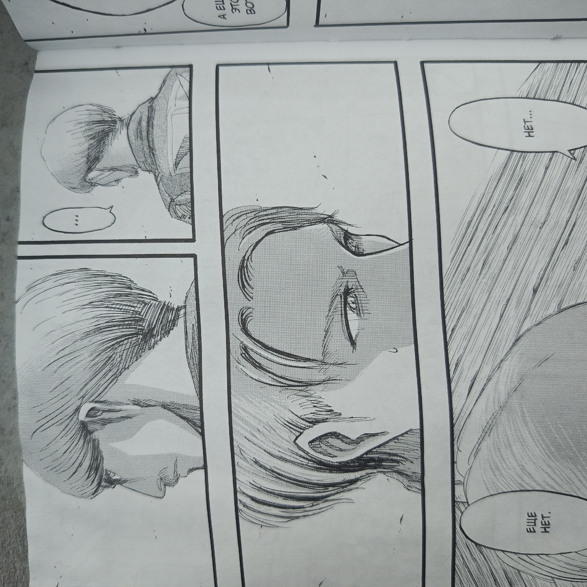 The image is a grayscale manga panel featuring multiple frames. The first frame shows a head and partial torso of a person, their back to the viewer, with a speech bubble containing three dots. The second frame presents a close-up, angled view of a person's face. The third frame includes part of a face with a speech bubble containing text. The background in the third frame is represented with lines, suggesting a wall or a similar surface. The manga panels are displayed on a white surface with some visible imperfections and smudges. The location is unknown.