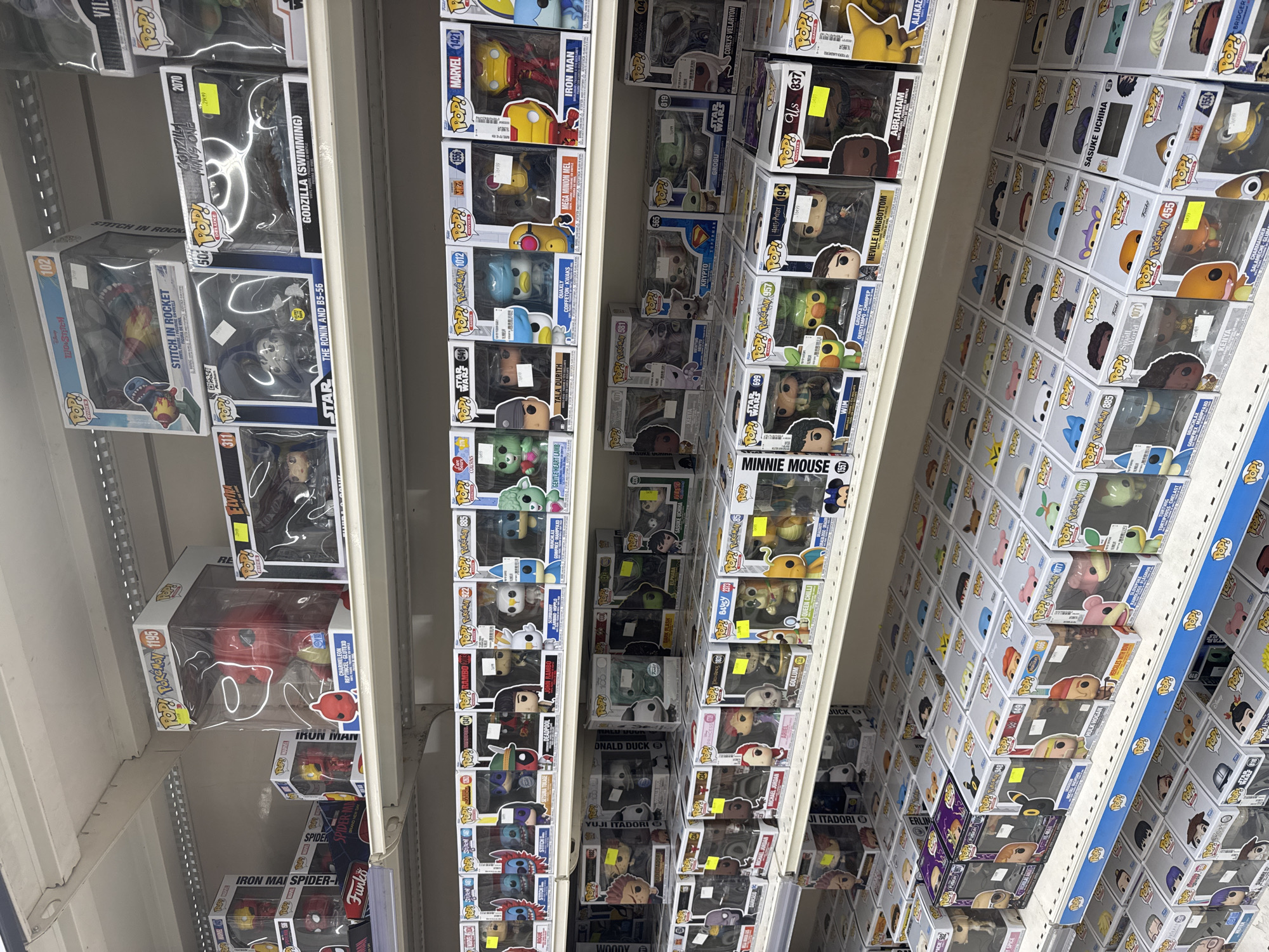 The image depicts a retail store interior, likely a toy or collectible shop, with shelves fully stocked with Funko Pop! vinyl figures in their original boxes. The figures are arranged in rows on multiple shelves, showcasing a wide variety of characters from different franchises, including Marvel, Star Wars, and Pokémon. The overall impression is one of abundance and organization, typical of a commercial display. The location provided, Leers, France, is a small town in the Nord department, suggesting this is a local business. No people are visible in the image, and the focus is entirely on the merchandise.