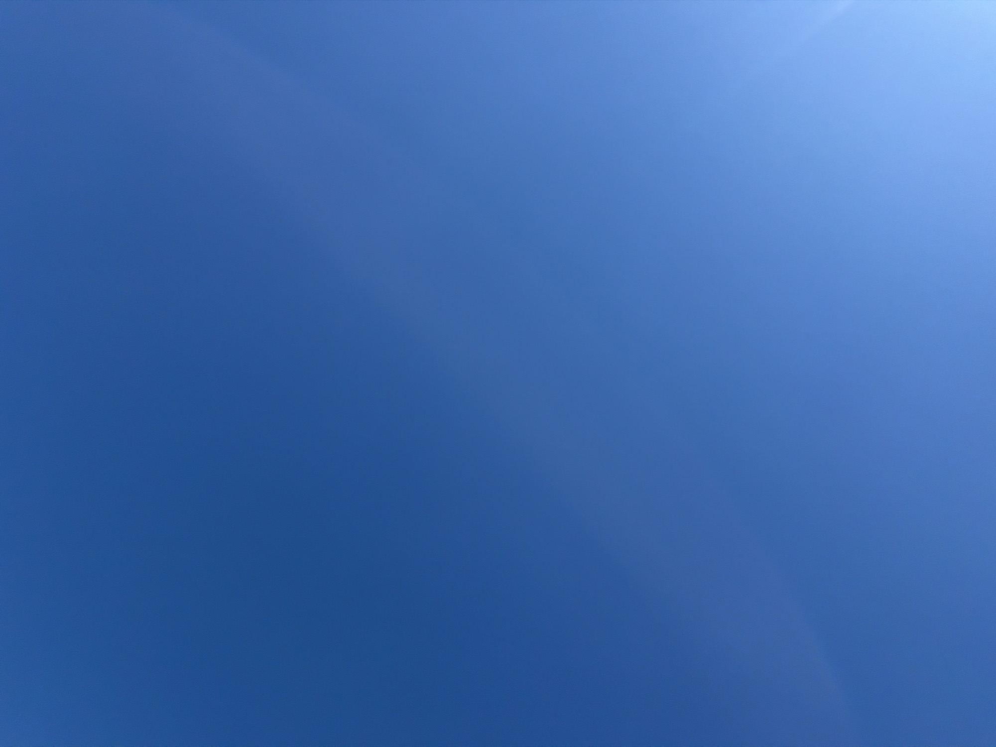 A clear blue sky is depicted in the image. There are no people, subjects, or objects visible. The environment is solely the sky. The image was captured in Riverhead, United States of America.