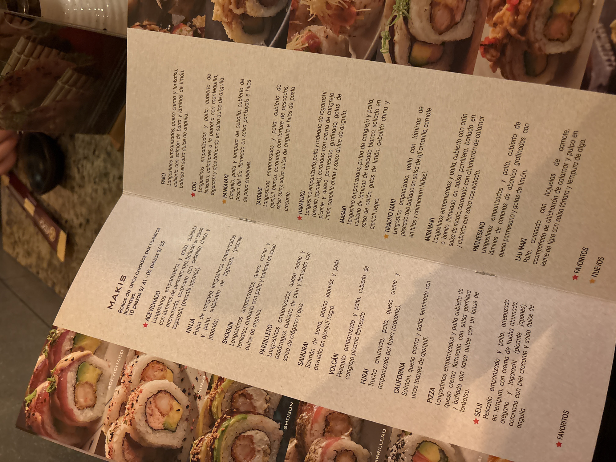 This media file displays a menu for a sushi restaurant, featuring various types of maki rolls. The menu is densely packed with text, listing the names and descriptions of different sushi creations, along with their prices. The backdrop of the menu is a photograph of several sushi rolls, artfully arranged and visually appealing. Some of the rolls are partially visible, showcasing their ingredients like avocado, shrimp, and sesame seeds. The overall presentation suggests a high-quality dining experience, with an emphasis on fresh ingredients and creative preparations. The menu text is in Spanish and includes names like "ACEVICHADO," "NINJA," "SHOGUN," and "CALIFORNIA," indicating a fusion of Japanese and Peruvian culinary influences. The prices are listed in Peruvian Soles (S/). The visual element of the sushi rolls adds to the appetite appeal of the menu.