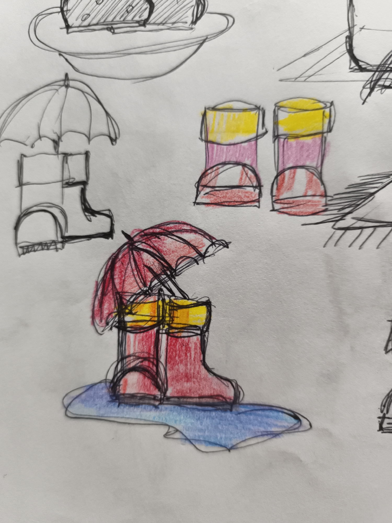 The image is a drawing on paper, featuring several sketched and colored objects that appear to be related to rain or outdoor activities. In the foreground, a pair of red boots with yellow tops is depicted under a red umbrella. The boots are standing in a puddle of blue. To the left of this scene, a black and white sketch of an umbrella and two blocks is visible. To the right, two more boots, colored pink and yellow, are drawn. Further to the right and above, other sketched elements are present, including what looks like part of a building or structure. There are no people depicted in the drawing, and the drawing itself is not located in Saint-Denis, France, as it is a sketch on paper.